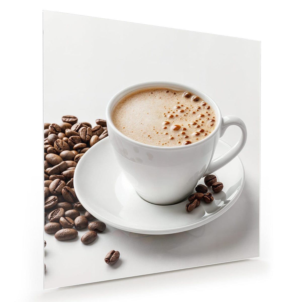 Weiße Tasse mit hellbraunem Milchschaum, Kaffeebohnen daneben, weißer Hintergrund