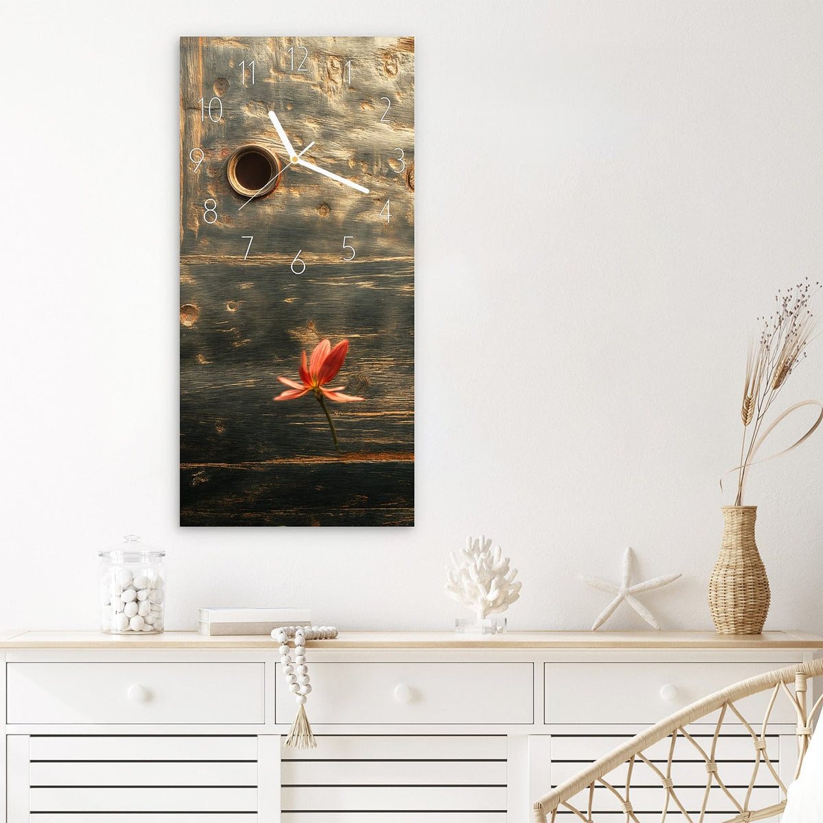 Wanduhr aus Glas im Hochformat Rote Blüten am Metall mit Ziffernblatt Elegant über einem weißen Sideboard