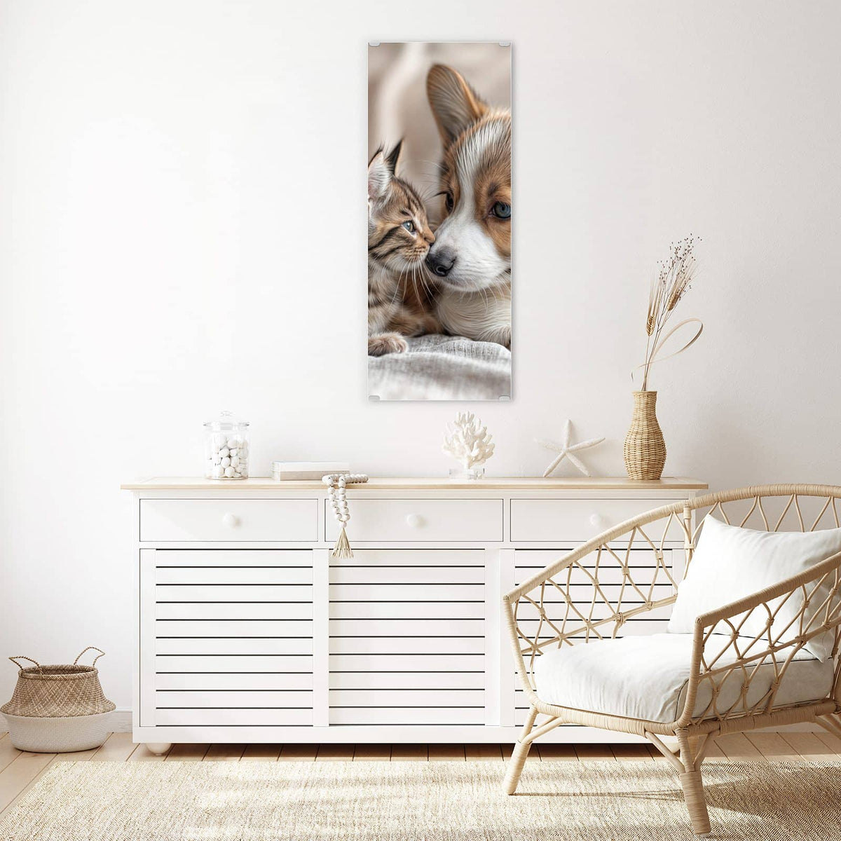 Wandbild aus Glas Welpe und Kätzchen über einem weißen Sideboard neben einem Rattansessel