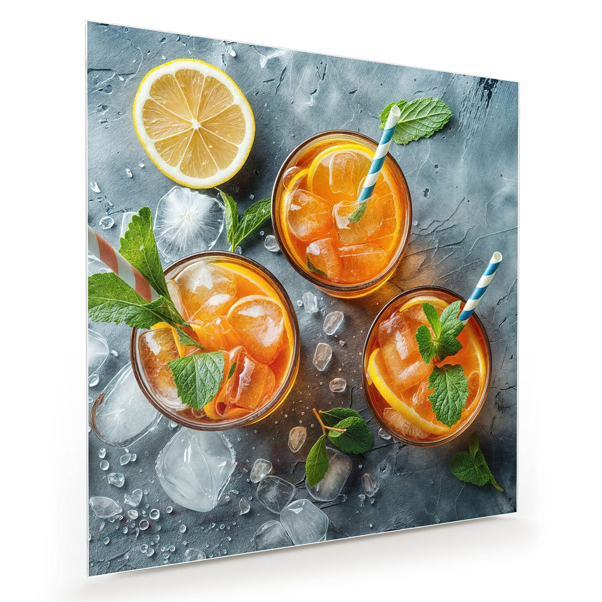 Drei Gläser mit orangefarbenem Eisgetränk, Zitrusscheiben, Minze und Papierstrohhalmen, daneben eine halbe Zitrone auf grauem Stein