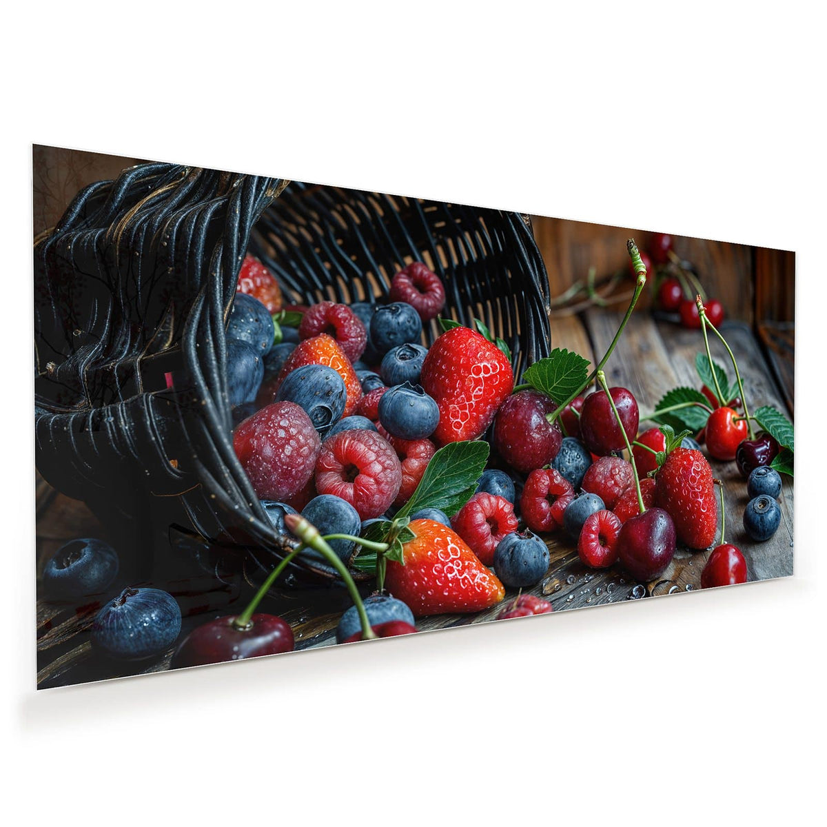 Umgekippter Weidenkorb, aus dem Erdbeeren, Heidelbeeren, Himbeeren und Kirschen auf Holz rollen