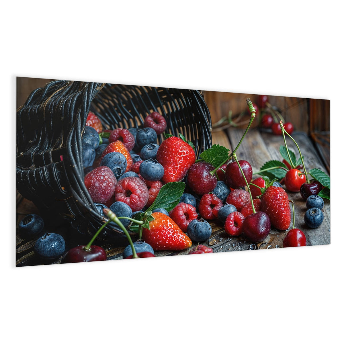 Umgekippter Weidenkorb, aus dem Erdbeeren, Heidelbeeren, Himbeeren und Kirschen auf Holz rollen