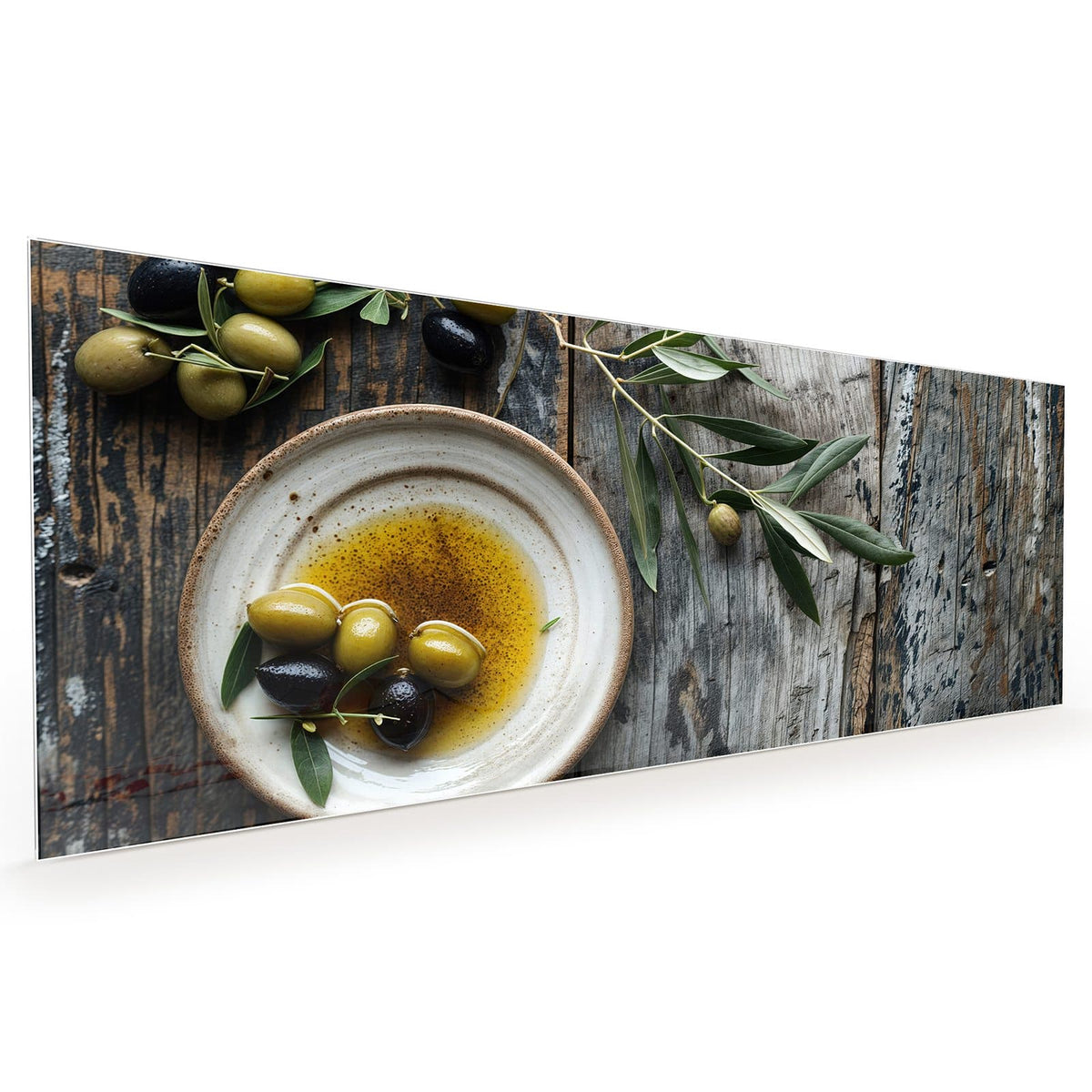 Küchenrückwand aus Glas im Hochformat: Flacher Keramikteller mit Olivenöl und grünen wie schwarzen Oliven, dazu Olivenzweige auf Holz #grösse_40 x 100 cm #grösse_50 x 125 cm #grösse_60 x 150 cm