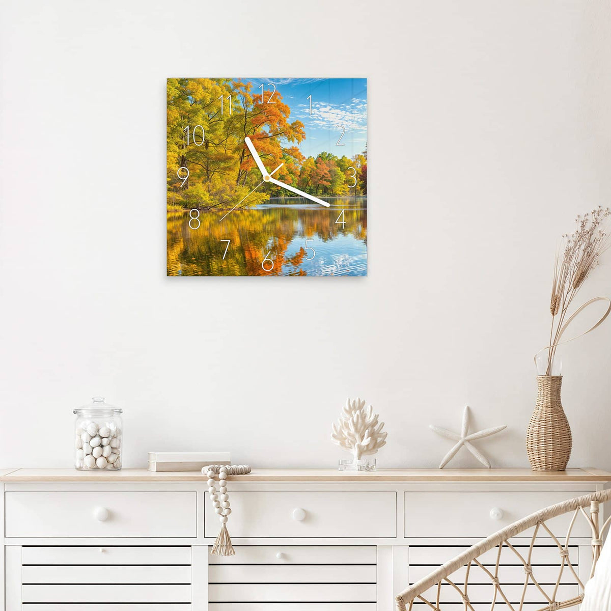 Quadratische Wanduhr aus Glas Spiegelung im Herbstsee mit Ziffernblatt Elegant über einem weißen Sideboard