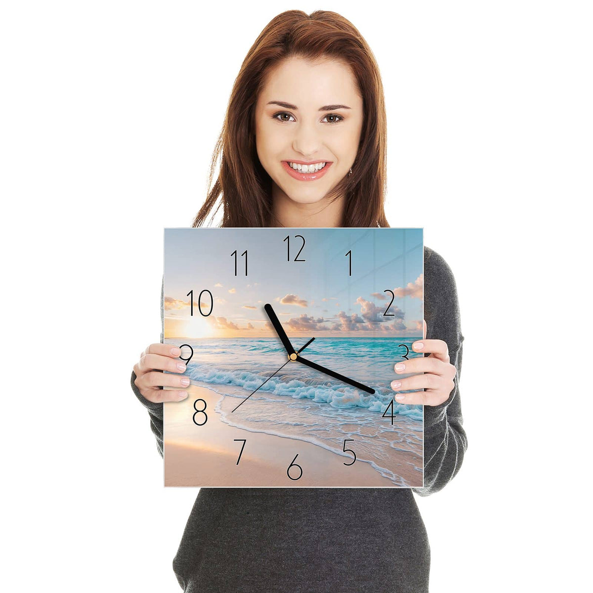 Quadratische Wanduhr aus Glas Sonnenaufgang am Strand in zwei Händen gehalten – Größenvergleich, 30 × 30 cm