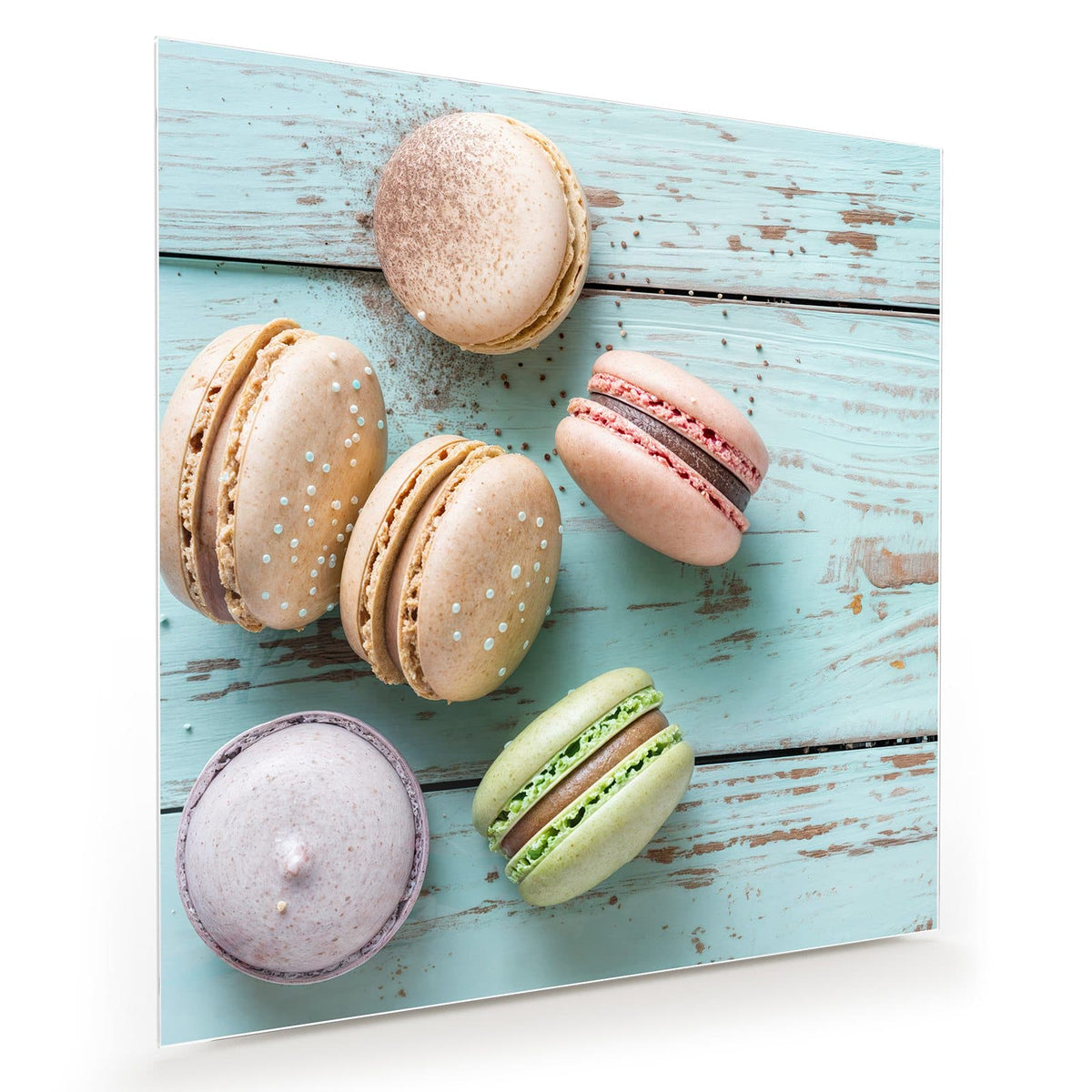 Sechs Macarons in Pastelltönen auf hellblau abgeblättertem Holz