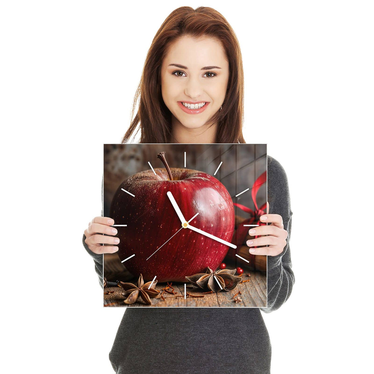 Quadratische Wanduhr aus Glas Zimt und Apfel in zwei Händen gehalten – Größenvergleich, 30 × 30 cm