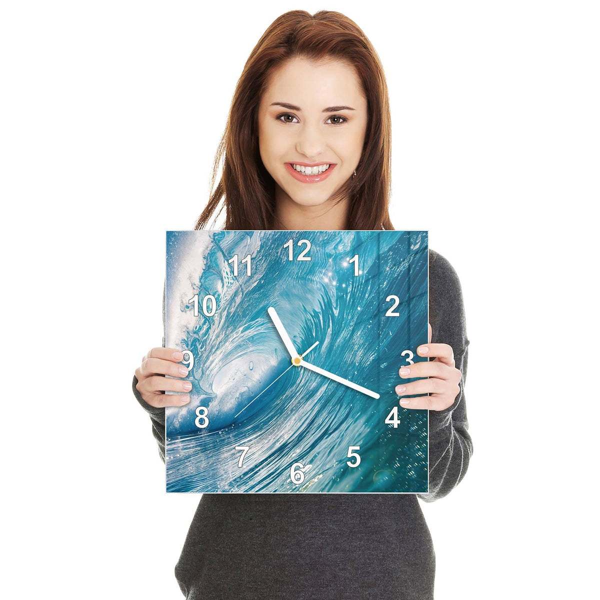 Quadratische Wanduhr aus Glas Blaue Welle mit Gischt in zwei Händen gehalten – Größenvergleich, 30 × 30 cm