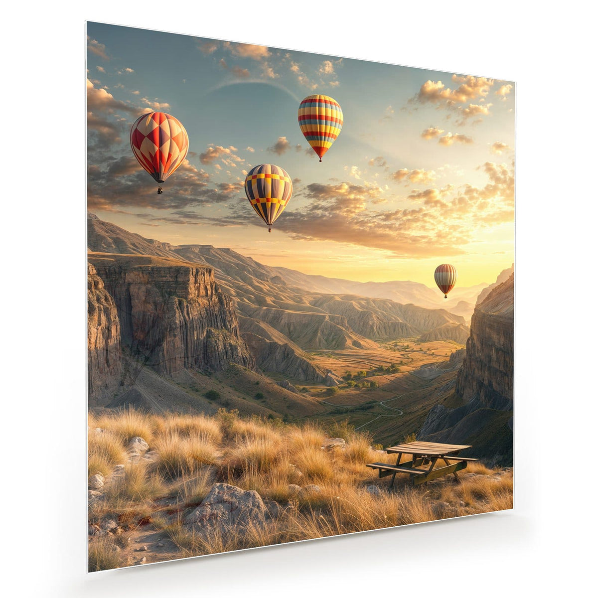 Vier Heißluftballons über einer Canyonlandschaft im Abendlicht, Picknicktisch im Vordergrund