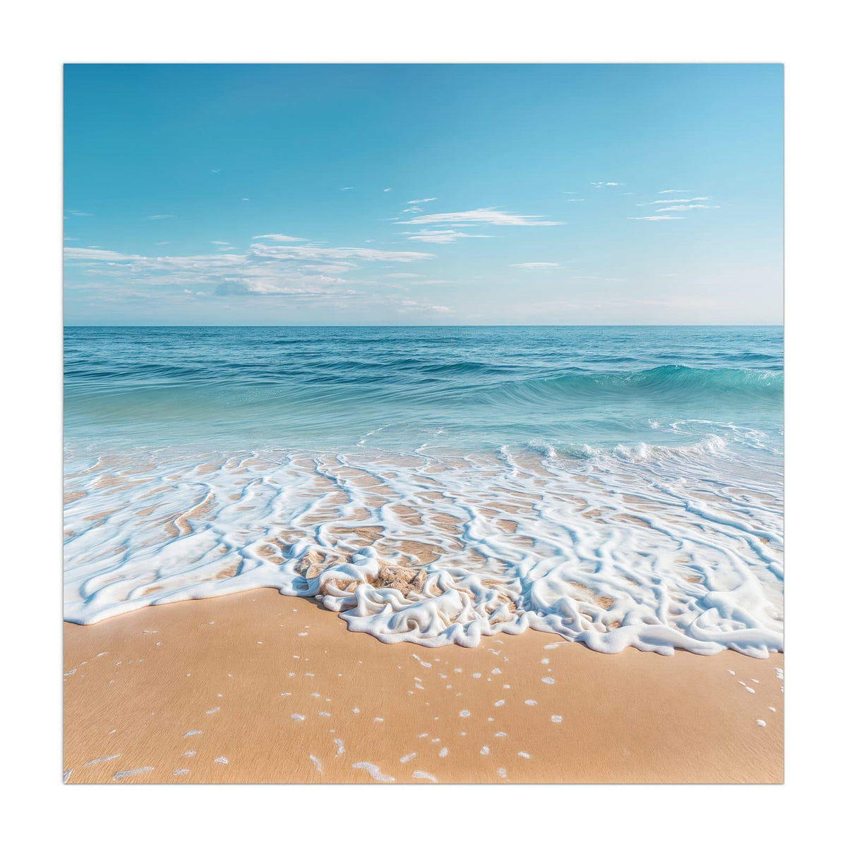 Weißer Schaumsaum einer auslaufenden Welle auf feinem Sand, blaues Meer, blauer Himmel
