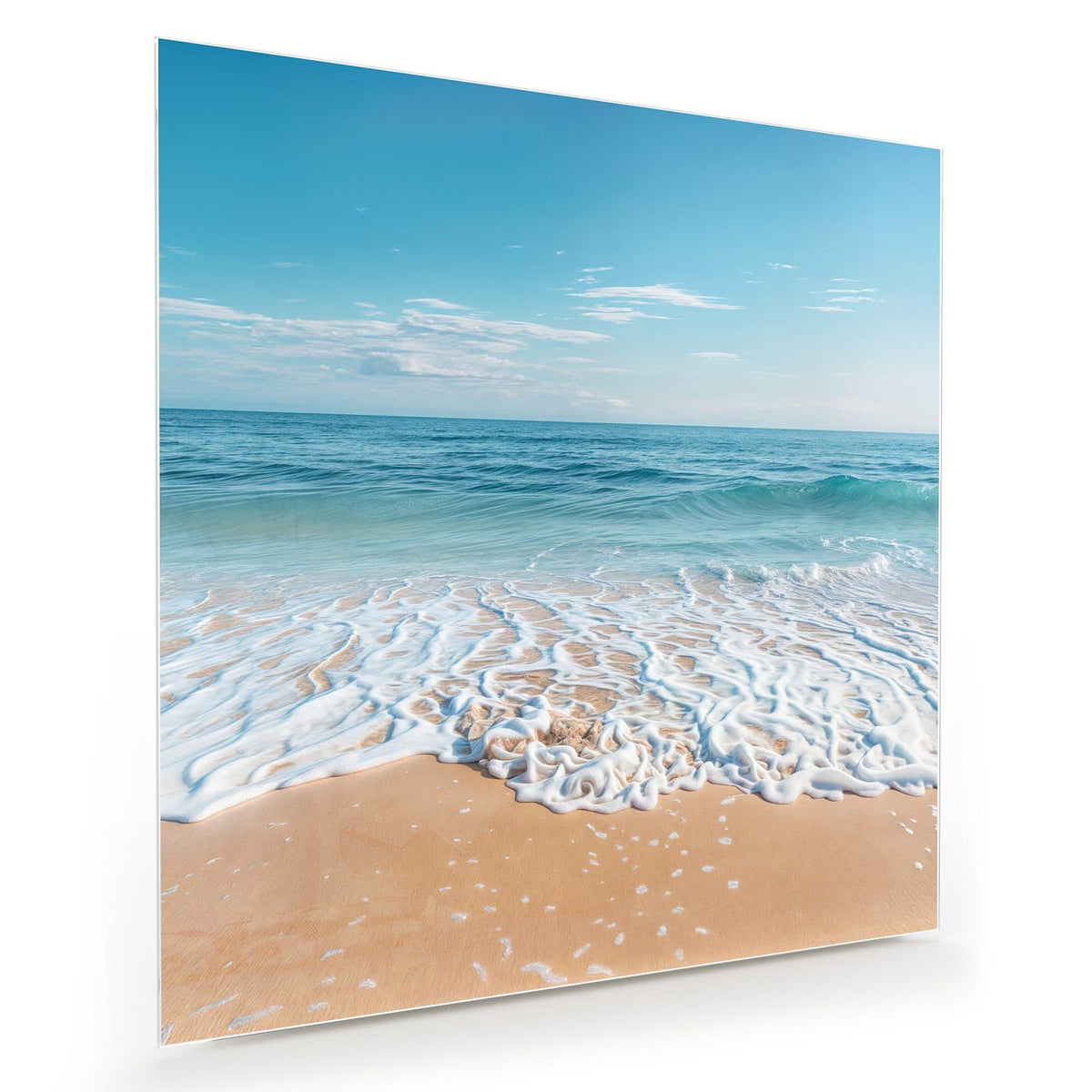Weißer Schaumsaum einer auslaufenden Welle auf feinem Sand, blaues Meer, blauer Himmel