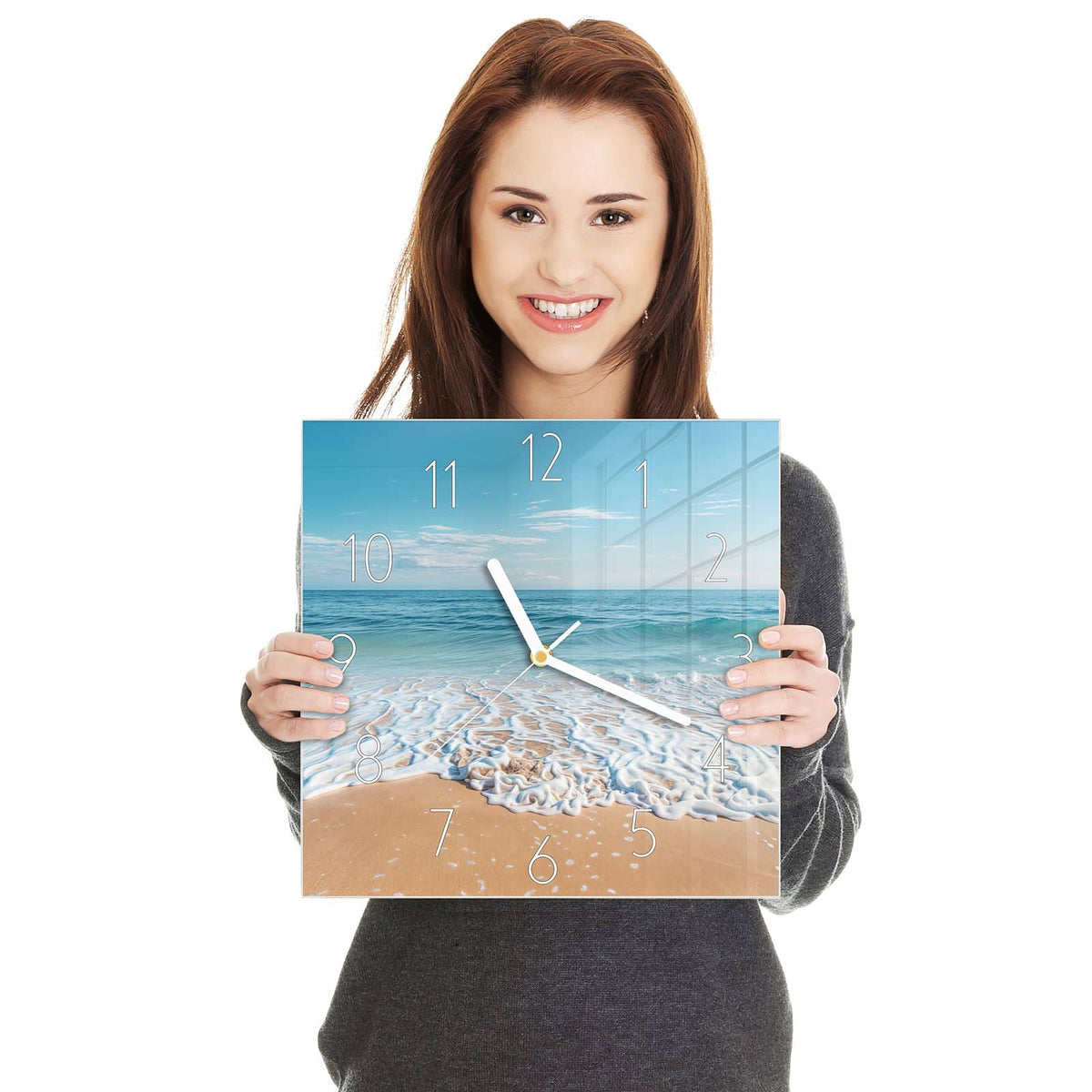 Weißer Schaumsaum einer auslaufenden Welle auf feinem Sand, blaues Meer, blauer Himmel