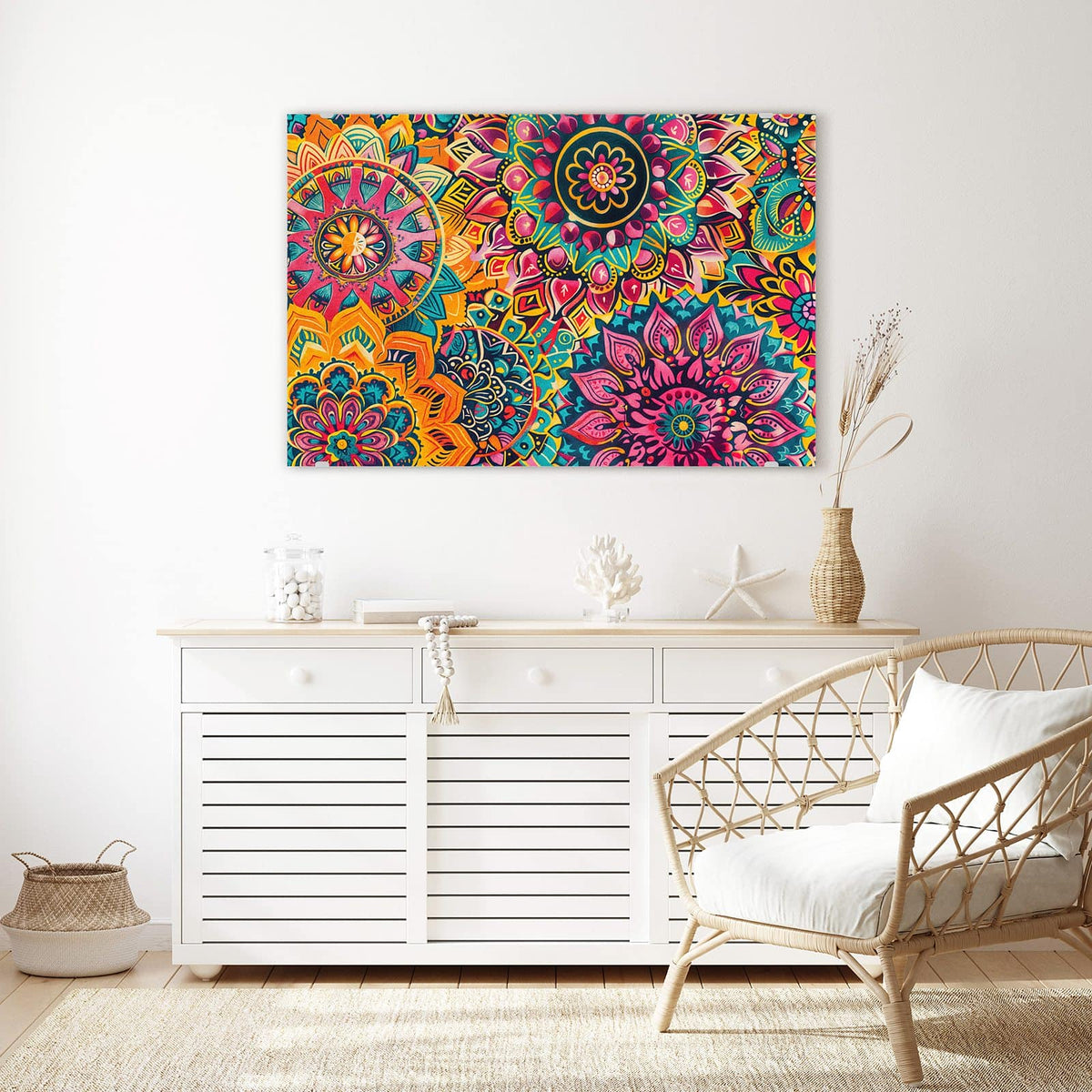 Wandbild aus Glas Bunte Mandalas über einem weißen Sideboard neben einem Rattansessel