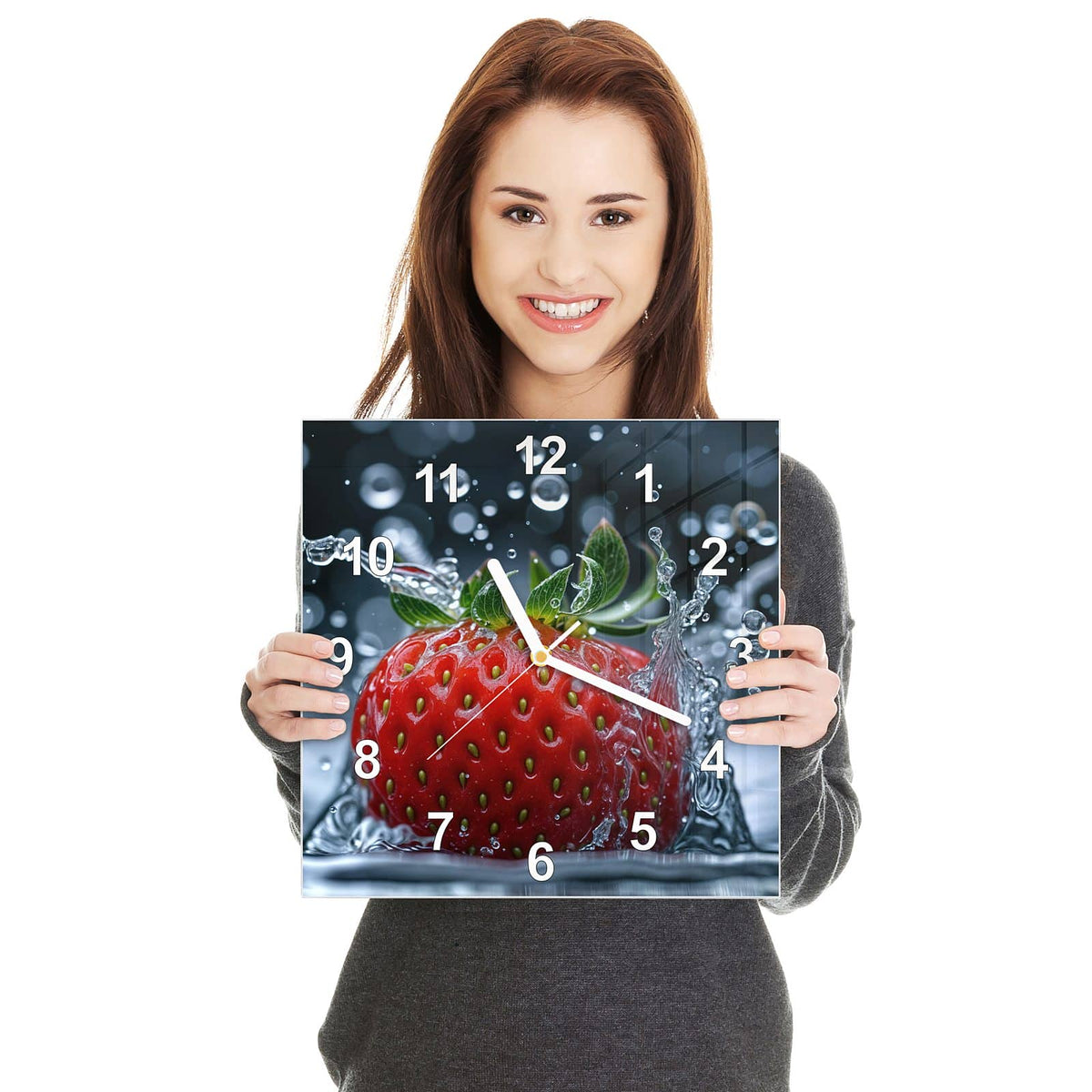 Quadratische Wanduhr aus Glas Erdbeere im Spritzwasser in zwei Händen gehalten – Größenvergleich, 30 × 30 cm