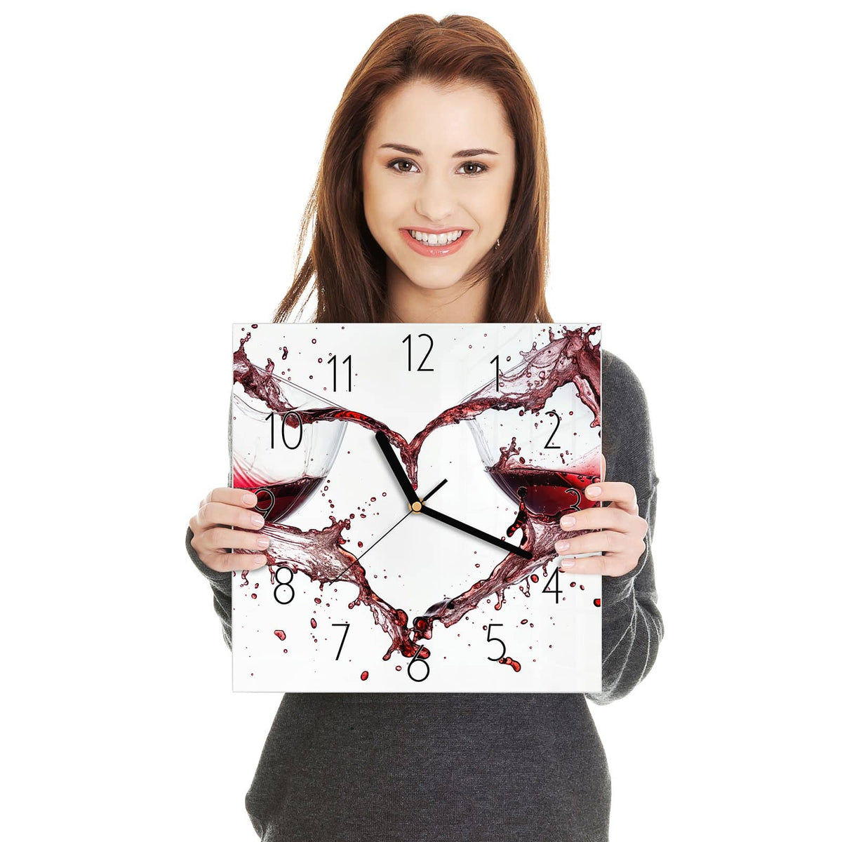 Zwei Gläser, aus denen Rotwein spritzt und vor weißem Grund ein Herz formt