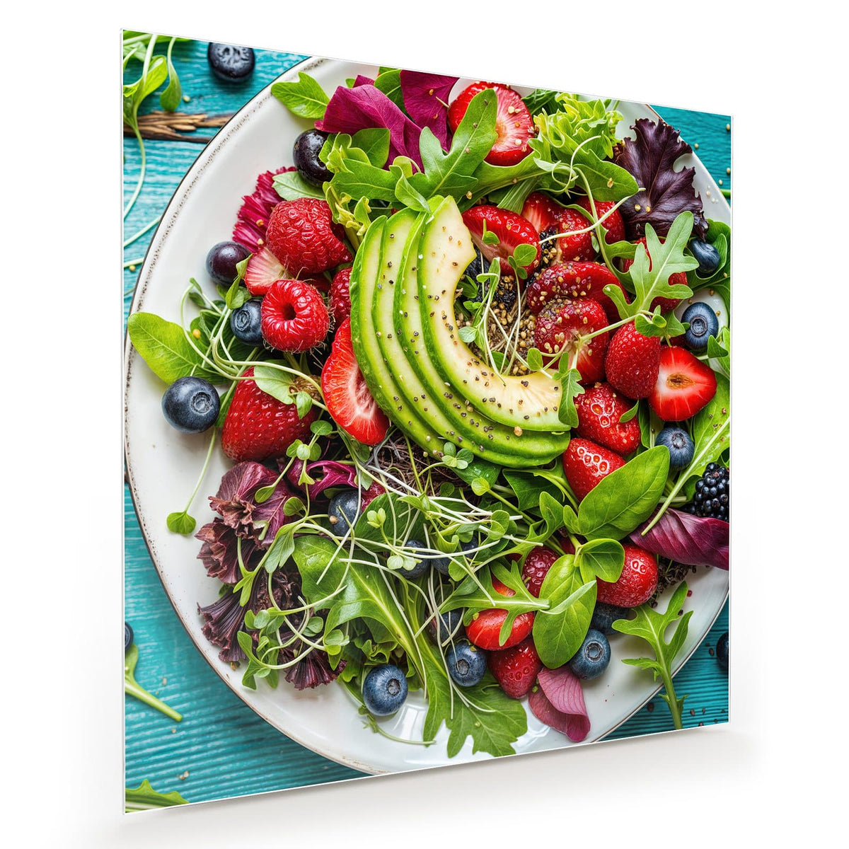Weißer Teller mit Blattsalat, Avocadoscheiben, Erdbeeren, Himbeeren und Blaubeeren auf türkisem Holz