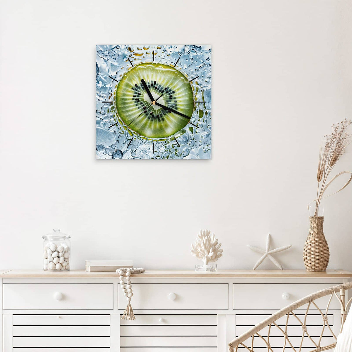 Quadratische Wanduhr aus Glas Kiwi in Wasserblasen mit Ziffernblatt Linie über einem weißen Sideboard