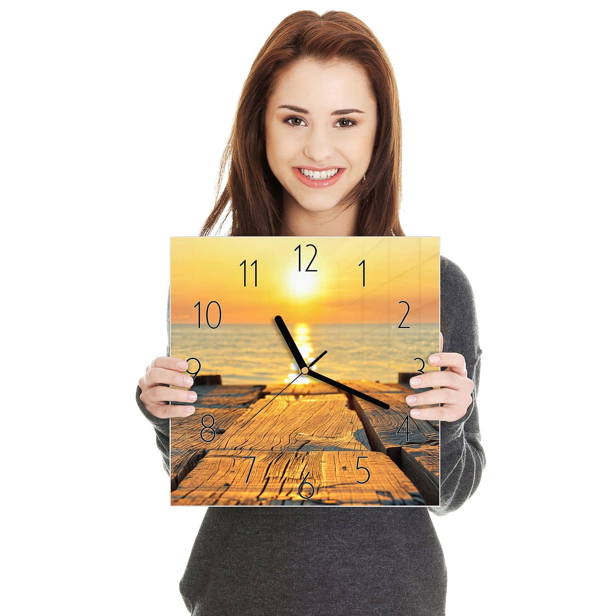 Quadratische Wanduhr aus Glas Holzsteg am Meer in zwei Händen gehalten – Größenvergleich, 30 × 30 cm
