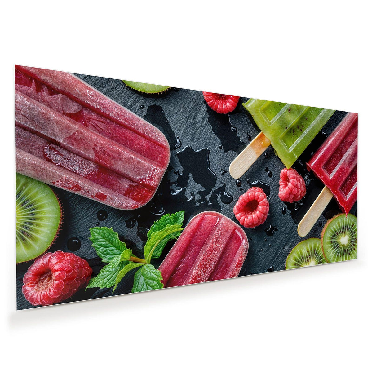 Grünes Kiwi-Eis und rotes Beereneis am Stiel auf dunkler Schieferplatte, dazu Himbeeren, Kiwischeiben und Minze