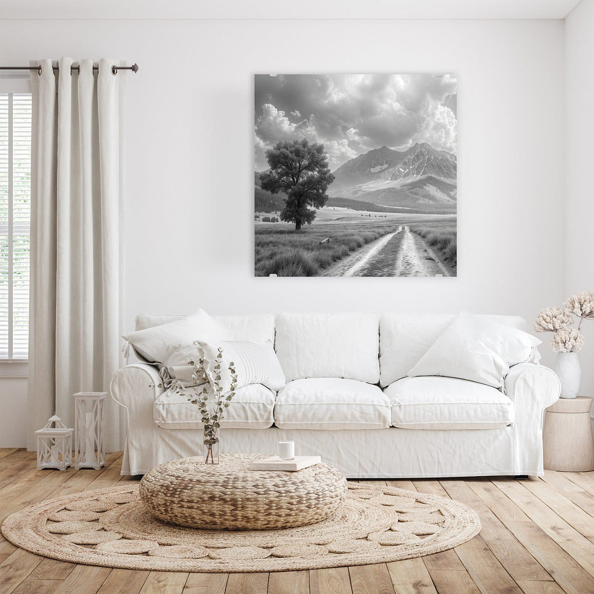 Glasbild Einsamer Baum vor Bergen an der Wand – Schwarzweißfoto: einzelner Baum links an einem Feldweg, dahinter Bergkette mit Wolkentürmen.