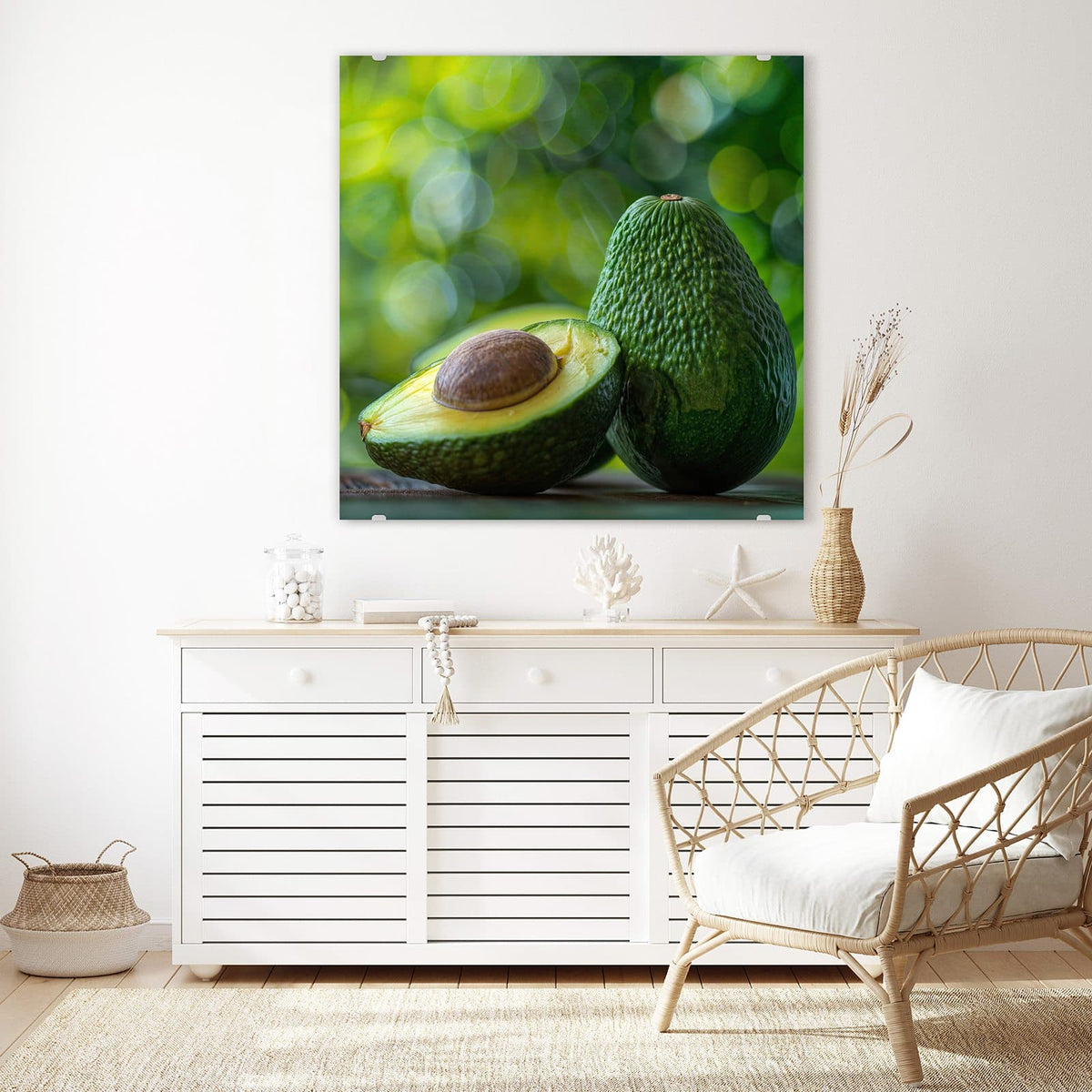 Glasbild Halbierte Avocado an der Wand – Halbierte Avocado mit Kern vor einer ganzen Avocado, grünes Bokeh im Hintergrund