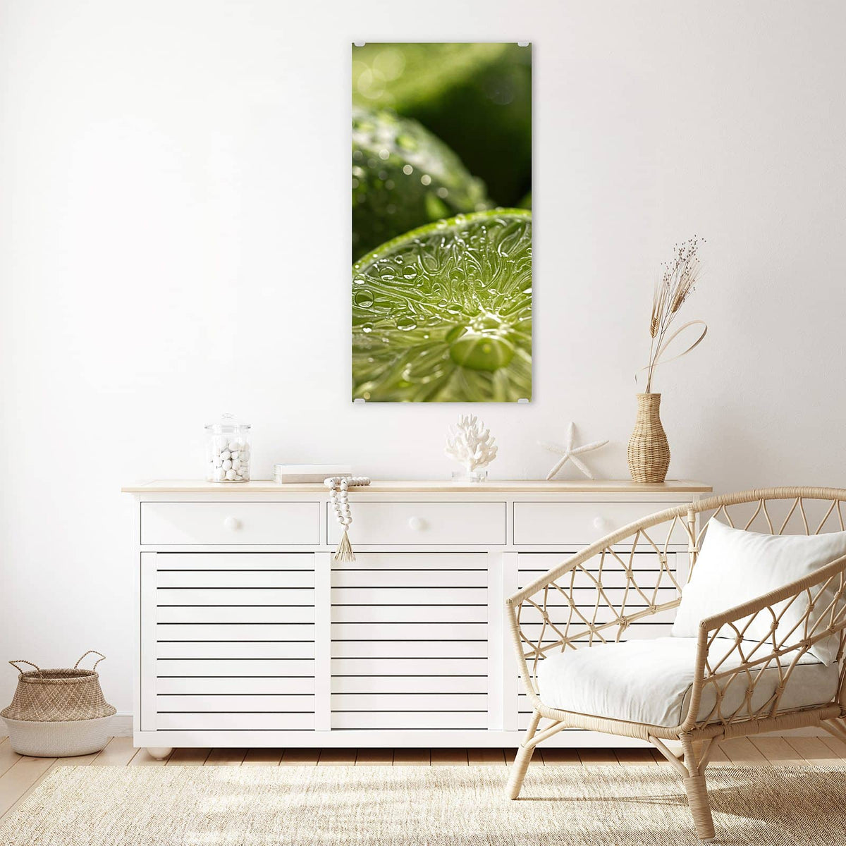 Glasbild Nasse Limettenscheibe an der Wand – Makro einer aufgeschnittenen Limettenhälfte voller Wassertropfen, dahinter unscharfe grüne Limetten