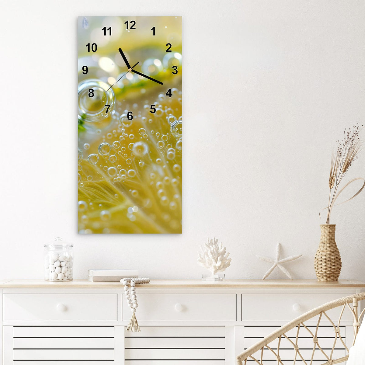 Wanduhr aus Glas im Hochformat Zitrone im Sprudel mit Ziffernblatt Modern über einem weißen Sideboard