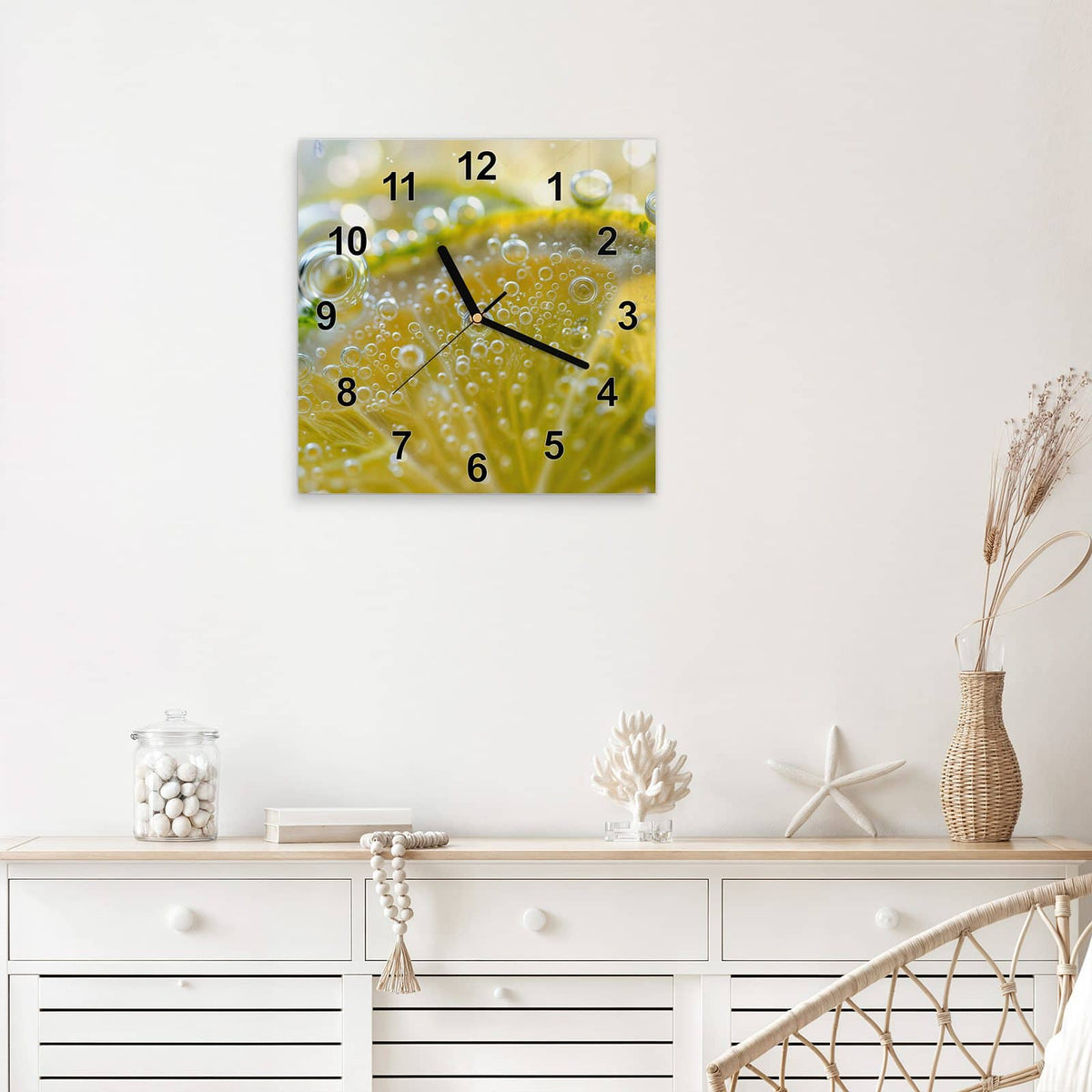 Quadratische Wanduhr aus Glas Zitrone im Sprudel mit Ziffernblatt Modern über einem weißen Sideboard