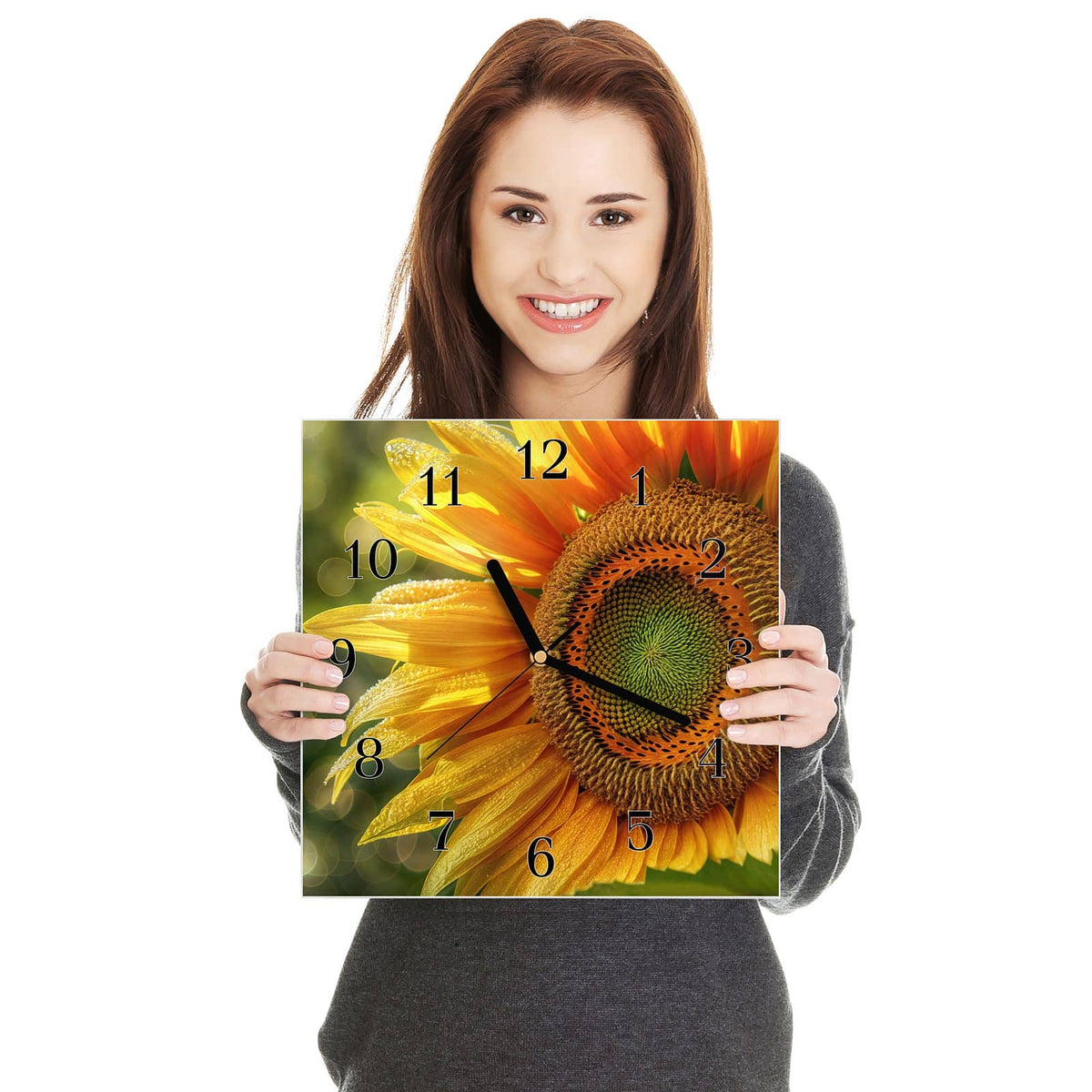 Quadratische Wanduhr aus Glas Sonnenblume mit Tau in zwei Händen gehalten – Größenvergleich, 30 × 30 cm