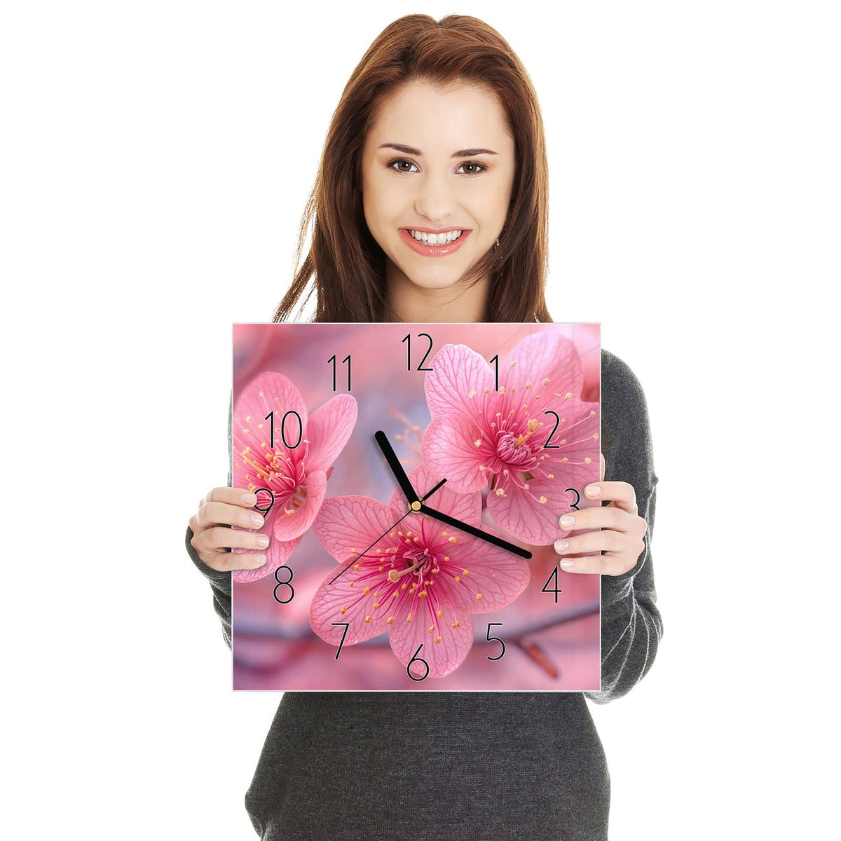 Drei kräftig pinke Blüten mit gelben Staubgefäßen in Nahaufnahme, rosa Bokeh dahinter
