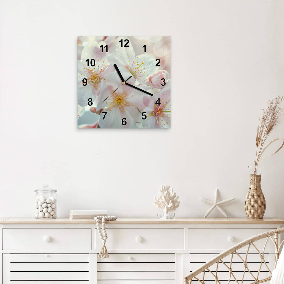 Quadratische Wanduhr aus Glas Weiße Frühlingsblüten mit Ziffernblatt Modern über einem weißen Sideboard