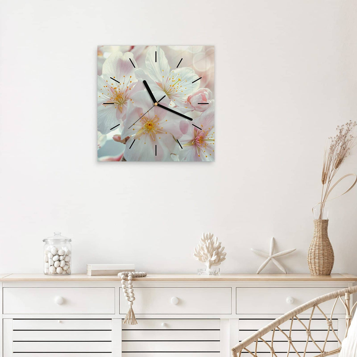 Quadratische Wanduhr aus Glas Weiße Frühlingsblüten mit Ziffernblatt Linie über einem weißen Sideboard
