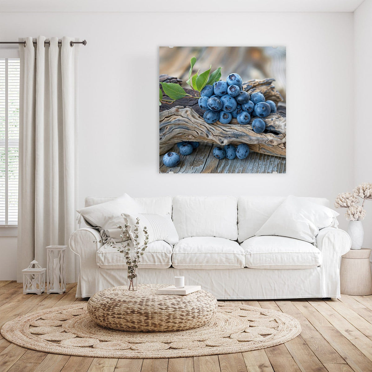 Glasbild Treibholz und Blaubeeren an der Wand – Haufen Blaubeeren mit grünen Blättern auf verwittertem Treibholzast, darunter graue Holzdielen