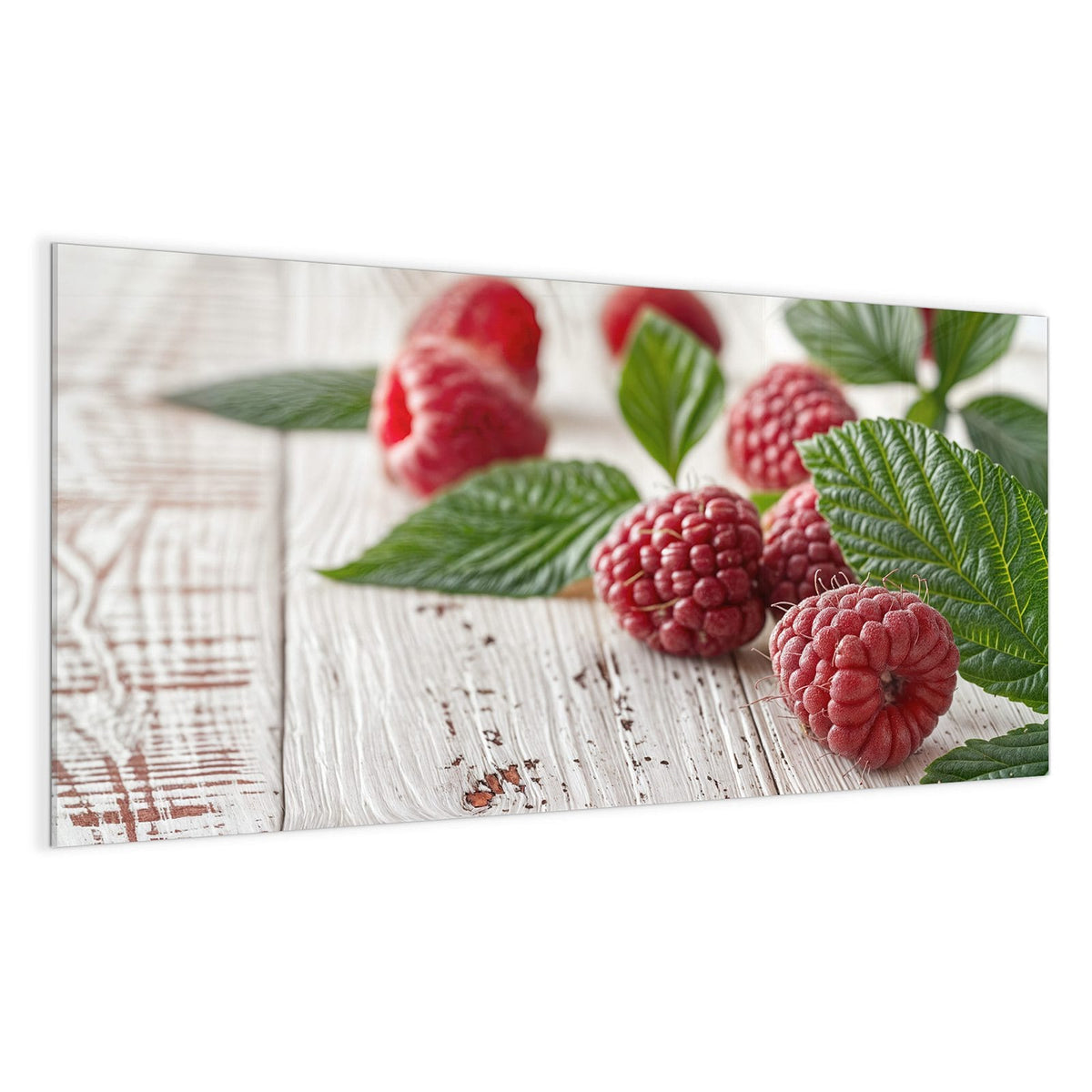 Himbeeren mit grünen Blättern auf weiß gestrichenem Holz