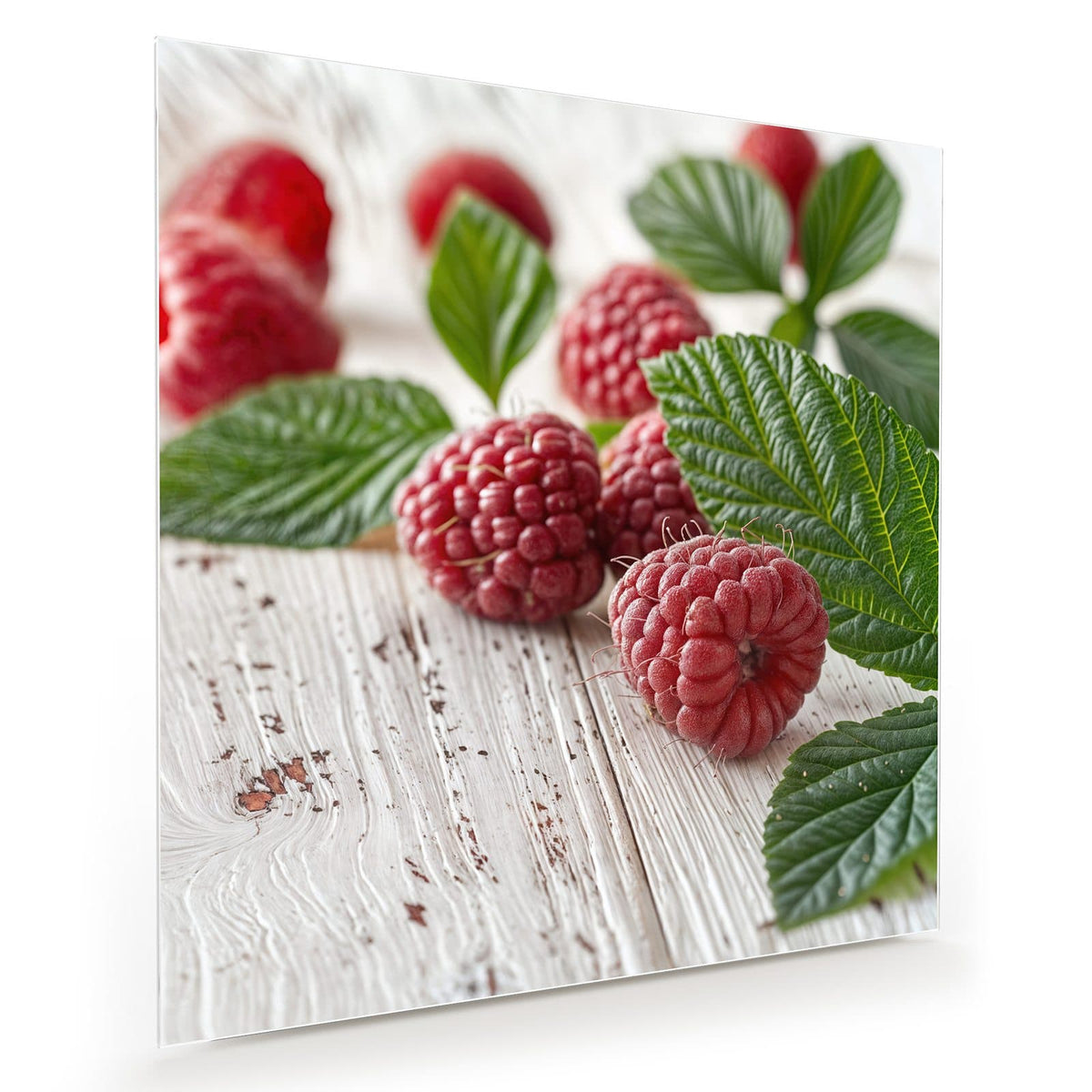 Himbeeren mit grünen Blättern auf weiß gestrichenem Holz