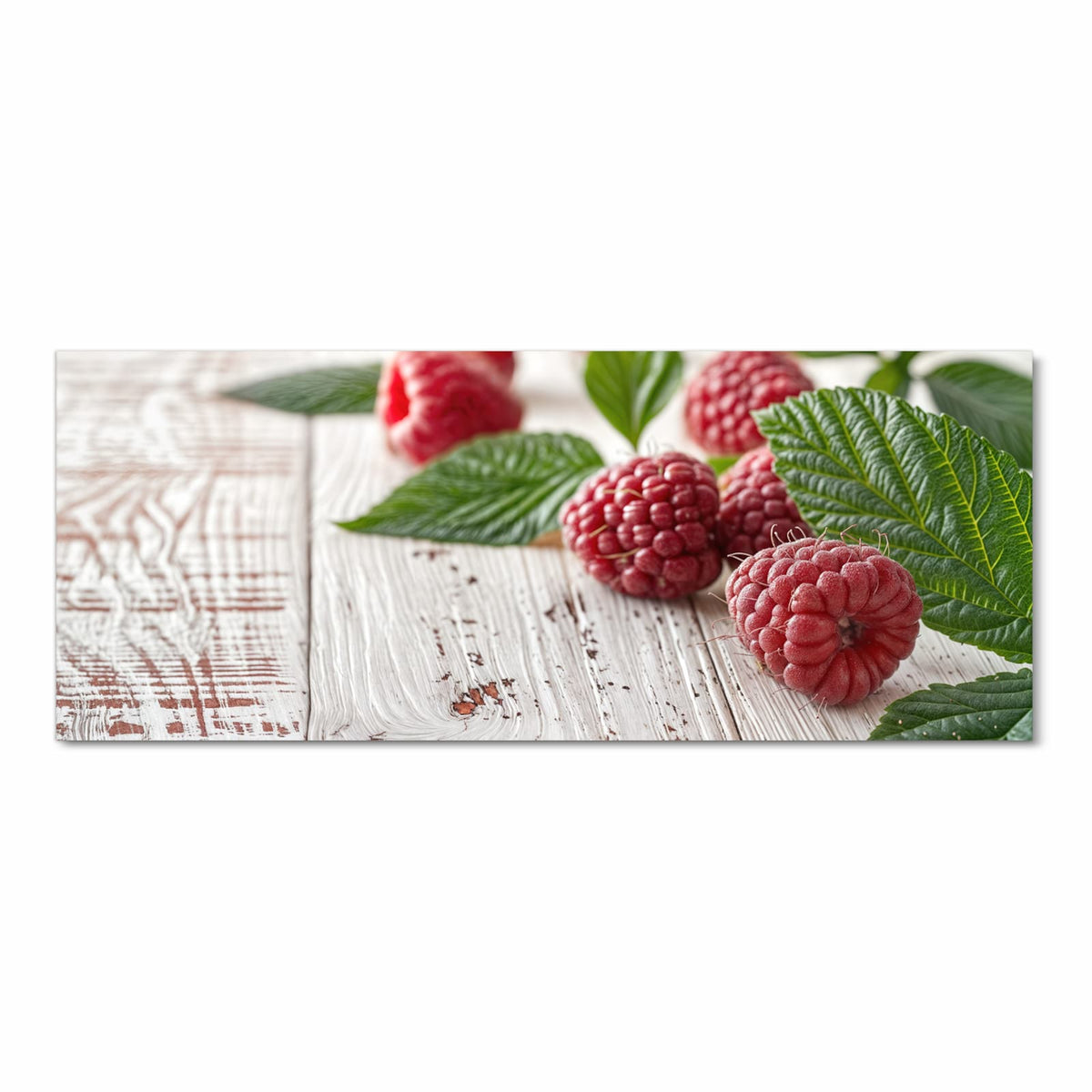 Himbeeren mit grünen Blättern auf weiß gestrichenem Holz