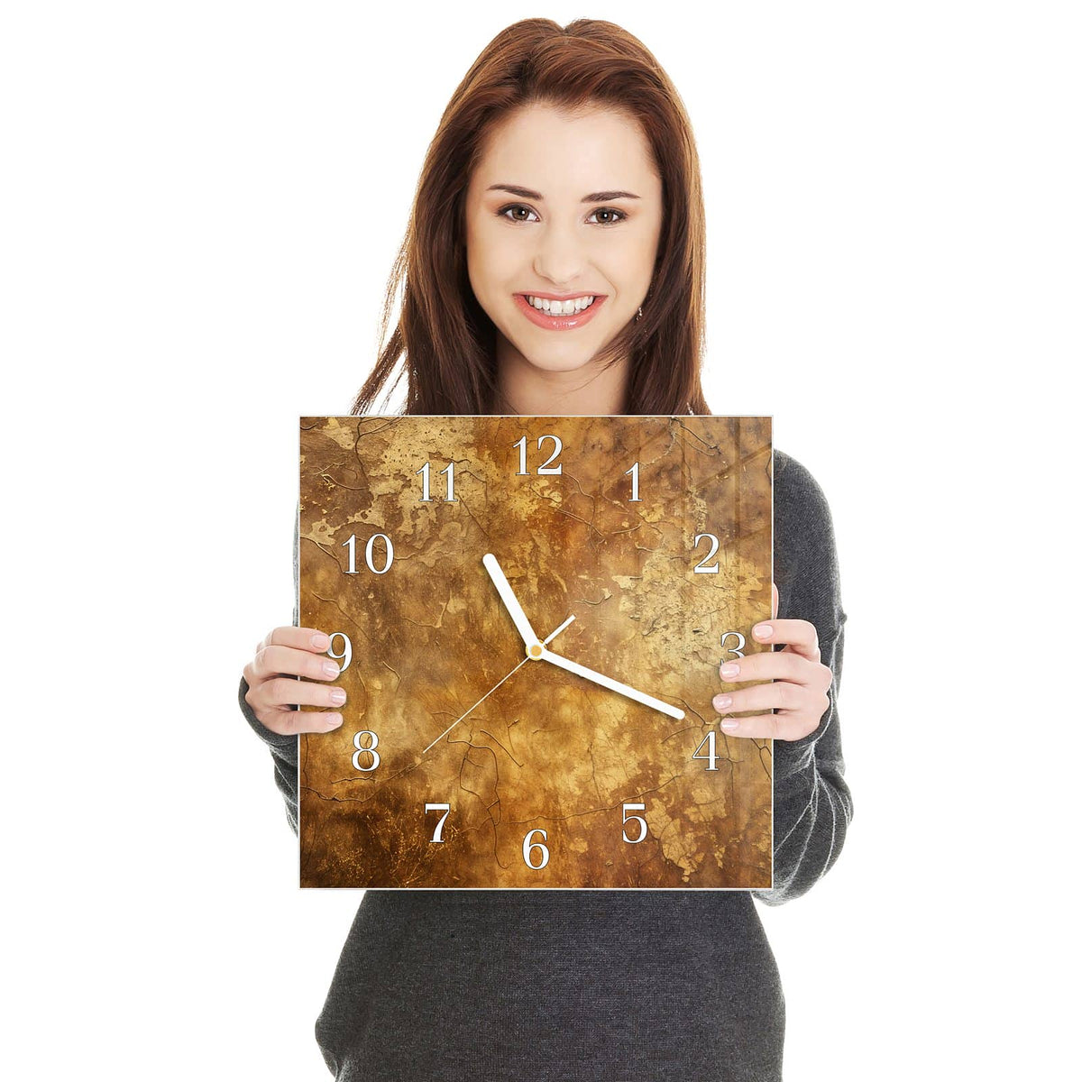 Quadratische Wanduhr aus Glas Risse in Ockerbraun in zwei Händen gehalten – Größenvergleich, 30 × 30 cm
