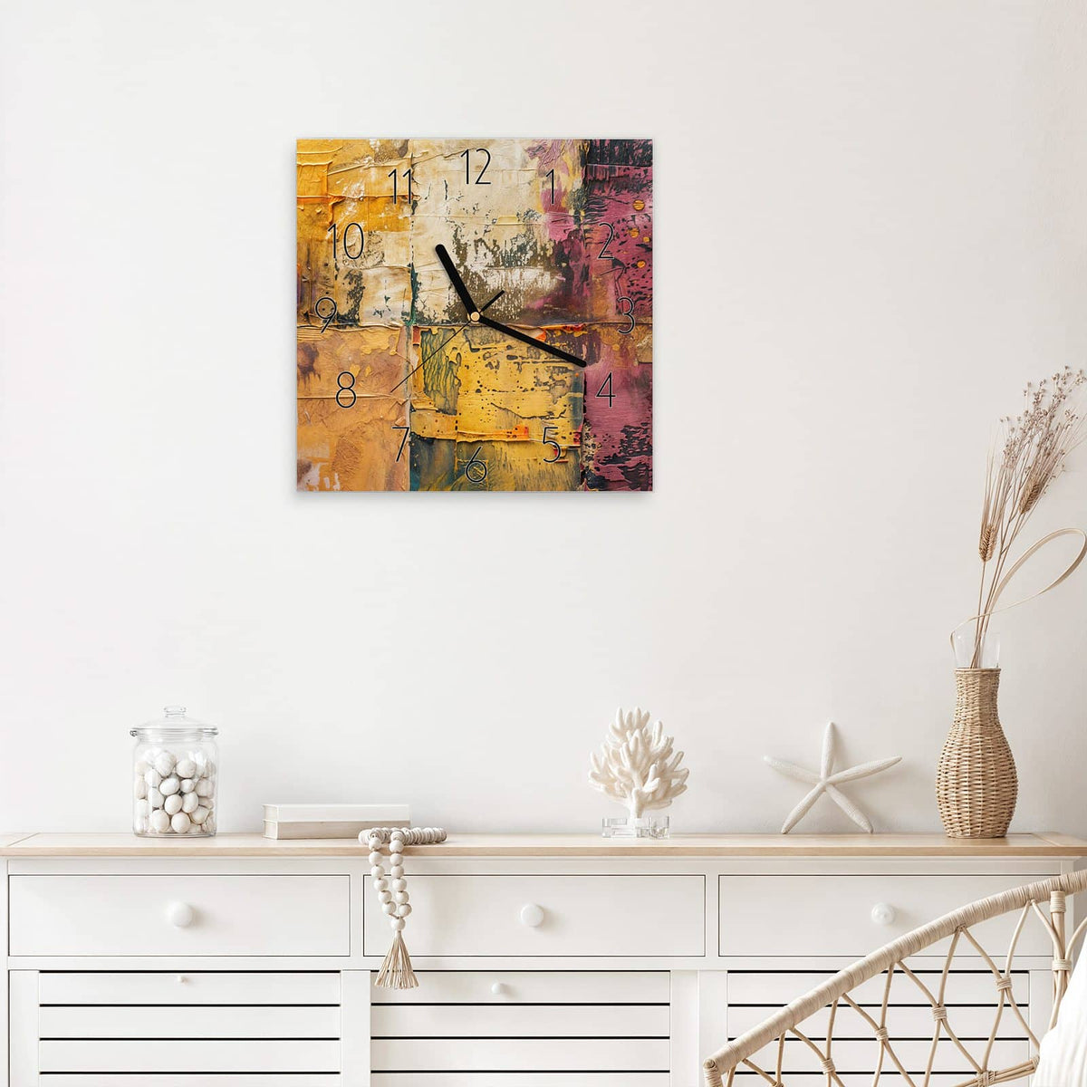 Quadratische Wanduhr aus Glas Papiercollage in Ocker mit Ziffernblatt Elegant über einem weißen Sideboard