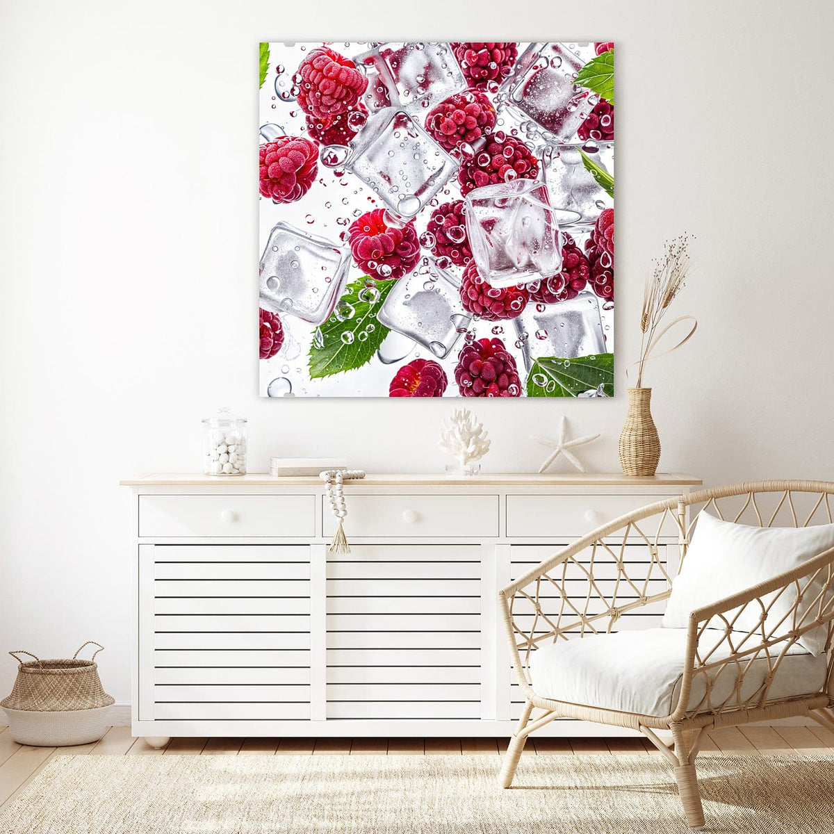 Glasbild Himbeeren im Eis an der Wand – Frische Himbeeren zwischen klaren Eiswürfeln mit Wassertropfen und grünen Blättern