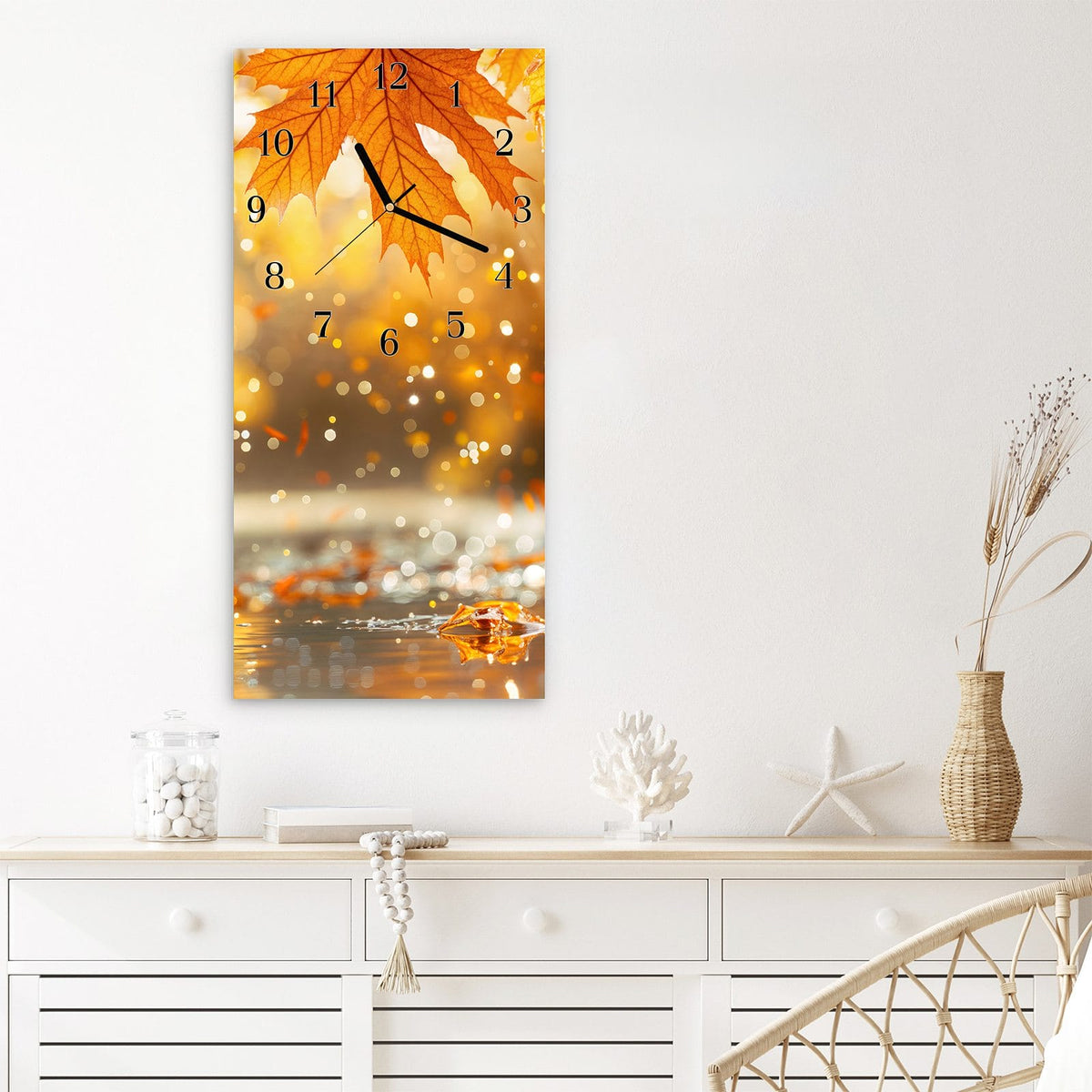 Wanduhr aus Glas im Hochformat Orange Ahornblätter mit Ziffernblatt Klassisch über einem weißen Sideboard