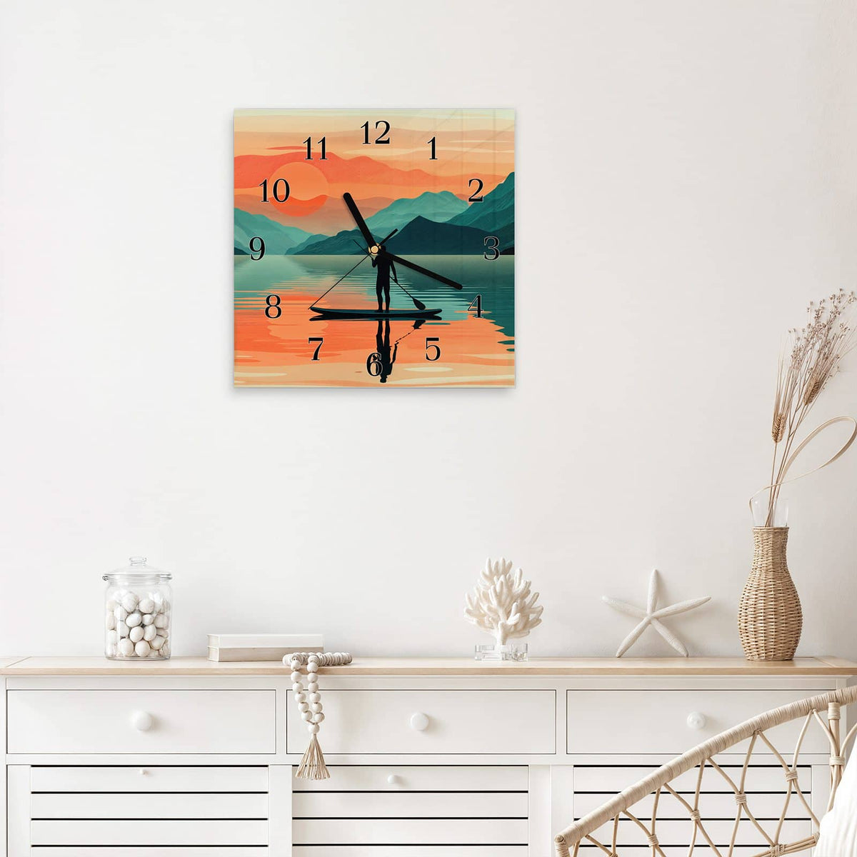 Quadratische Wanduhr aus Glas Paddler im Abendrot mit Ziffernblatt Klassisch über einem weißen Sideboard