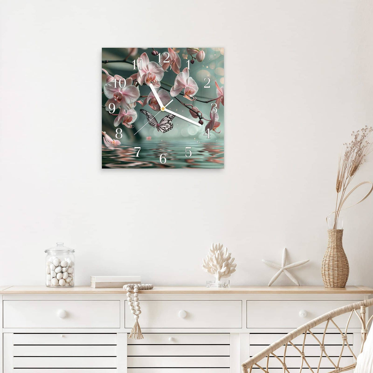 Quadratische Wanduhr aus Glas Orchidee am Wasser mit Ziffernblatt Klassisch über einem weißen Sideboard