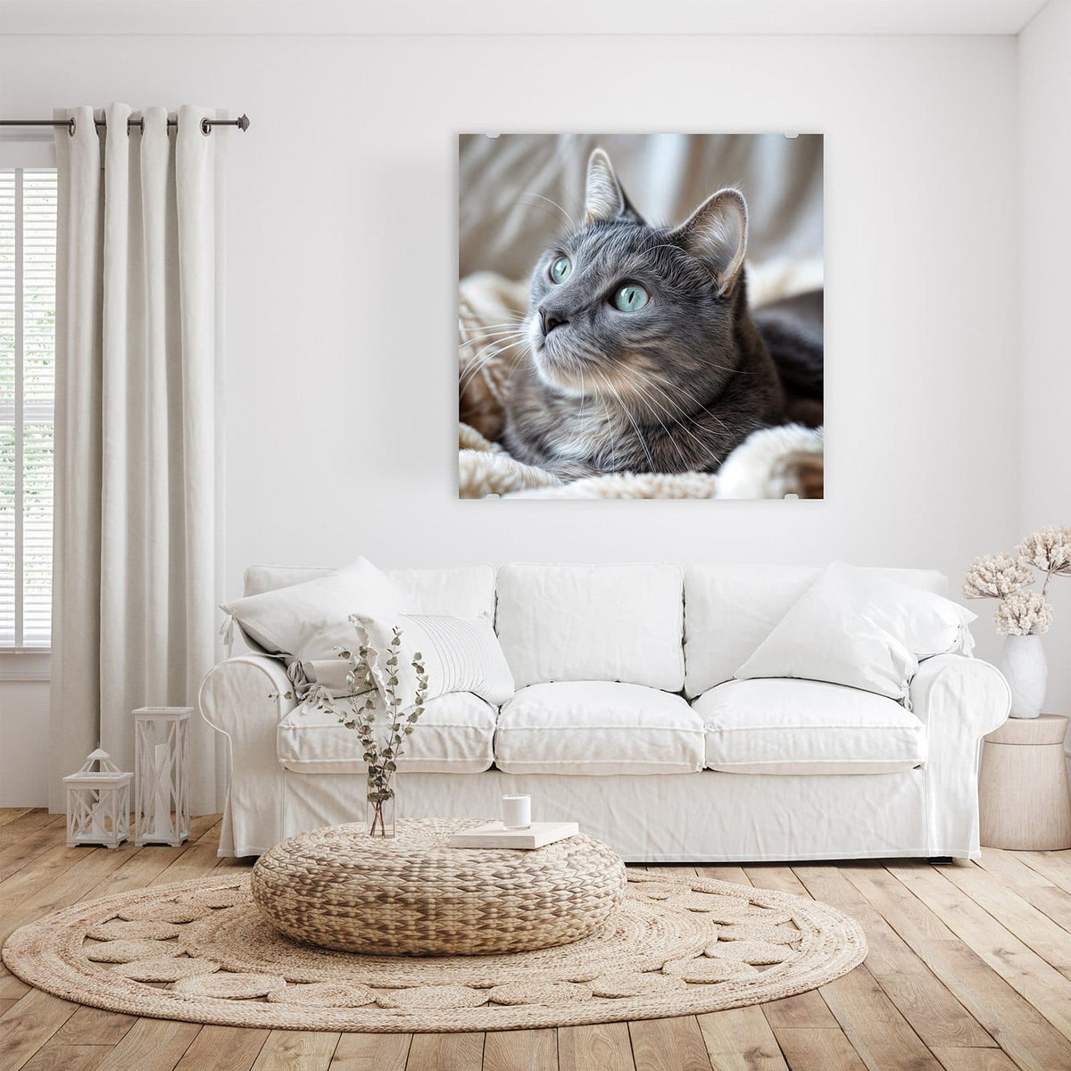 Graue Katze mit grüntürkisen Augen liegt auf einer flauschigen hellen Decke, Blick nach oben
