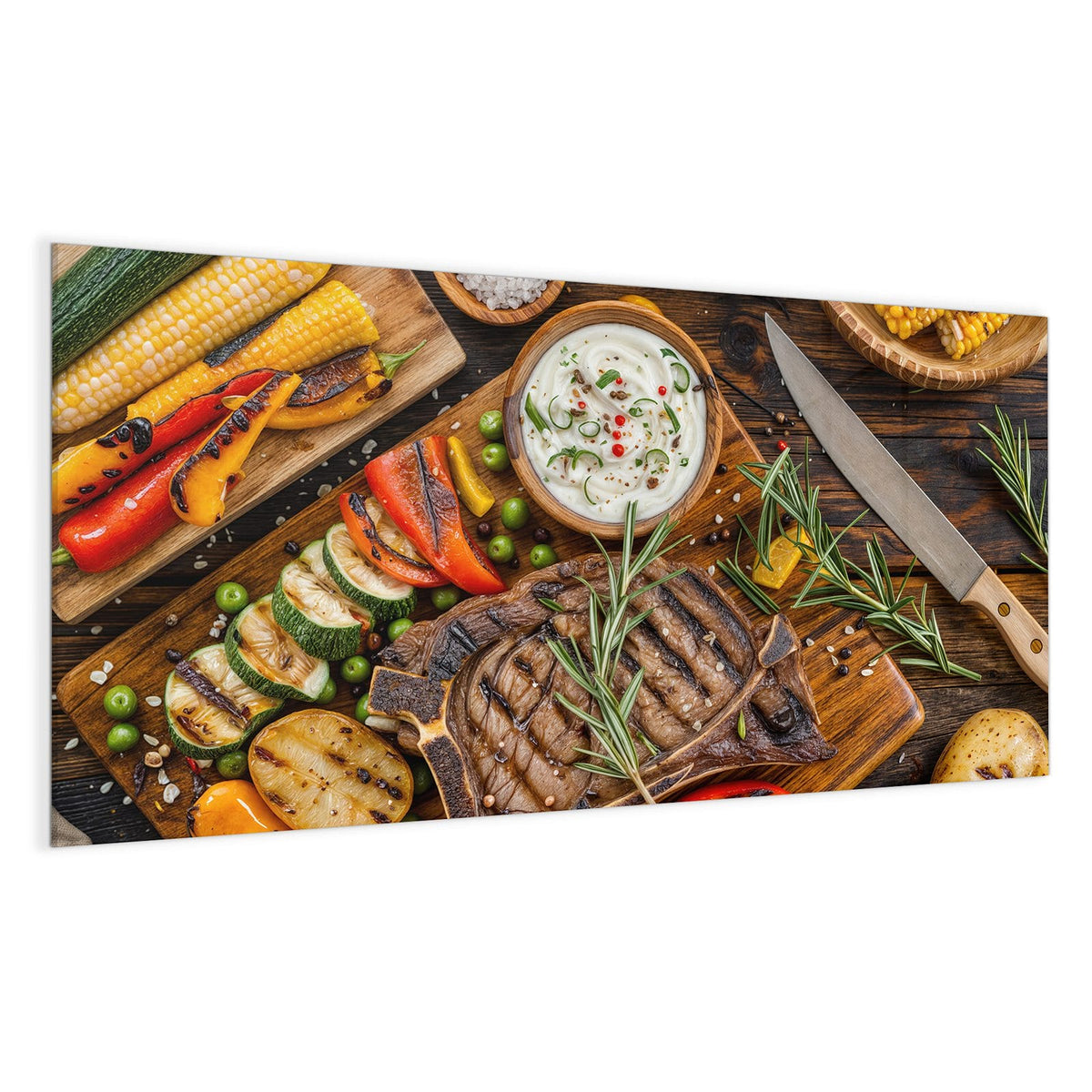 Gegrilltes T-Bone-Steak mit Rosmarin auf Holzbrett, daneben Grillgemüse, Mais, Kartoffeln und eine Dip-Schale.