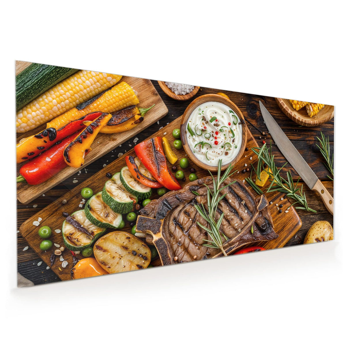 Küchenrückwand aus Glas im Hochformat: Gegrilltes T-Bone-Steak mit Rosmarin auf Holzbrett, daneben Grillgemüse, Mais, Kartoffeln und eine Dip-Schale.