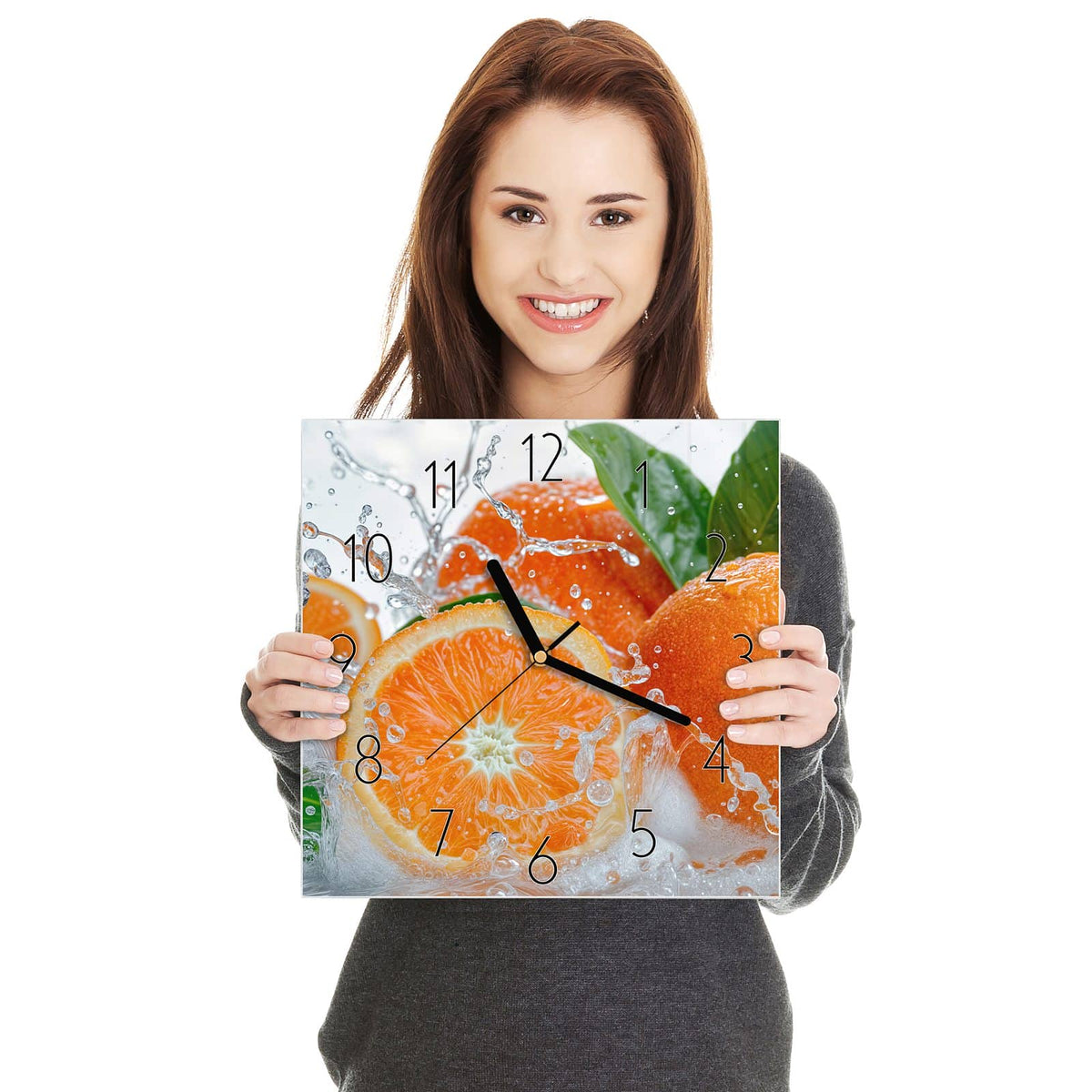 Ganze Orangen und eine Orangenscheibe im aufspritzenden Wasser mit grünen Blättern