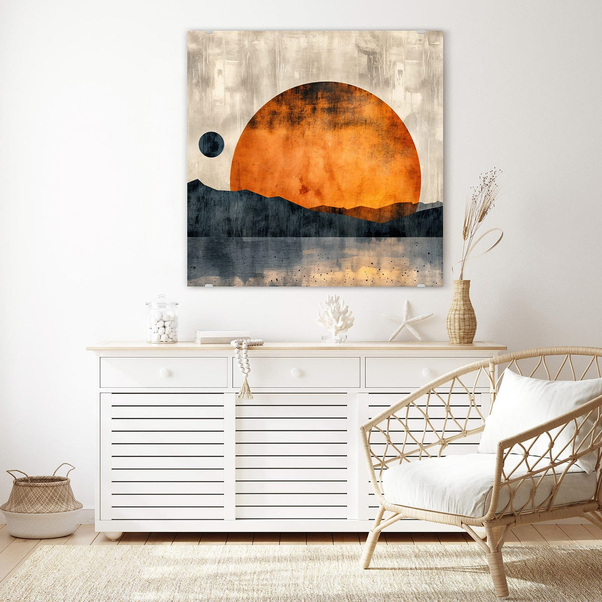 Glasbild Orange Sonne über Bergen an der Wand – Große orange Sonnenscheibe über dunkelblauen Bergsilhouetten und Wasser, links ein kleiner dunkler Mond.
