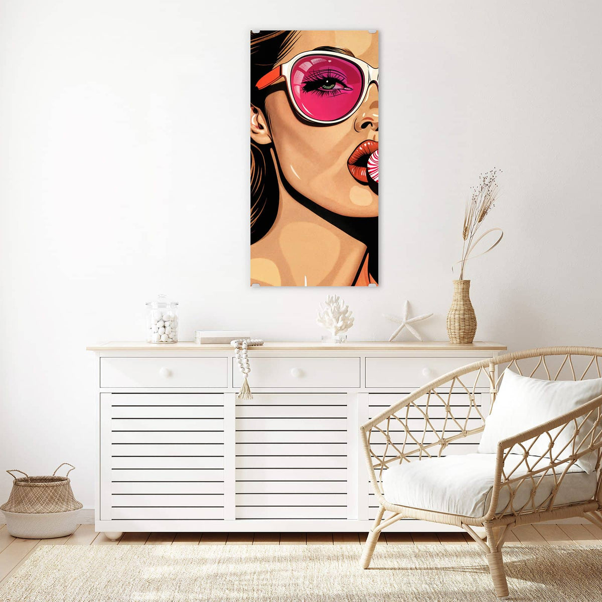 Wandbild aus Glas Pinke Sonnenbrille über einem weißen Sideboard neben einem Rattansessel