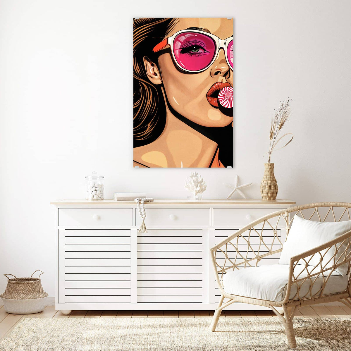Wandbild aus Glas Pinke Sonnenbrille über einem weißen Sideboard neben einem Rattansessel