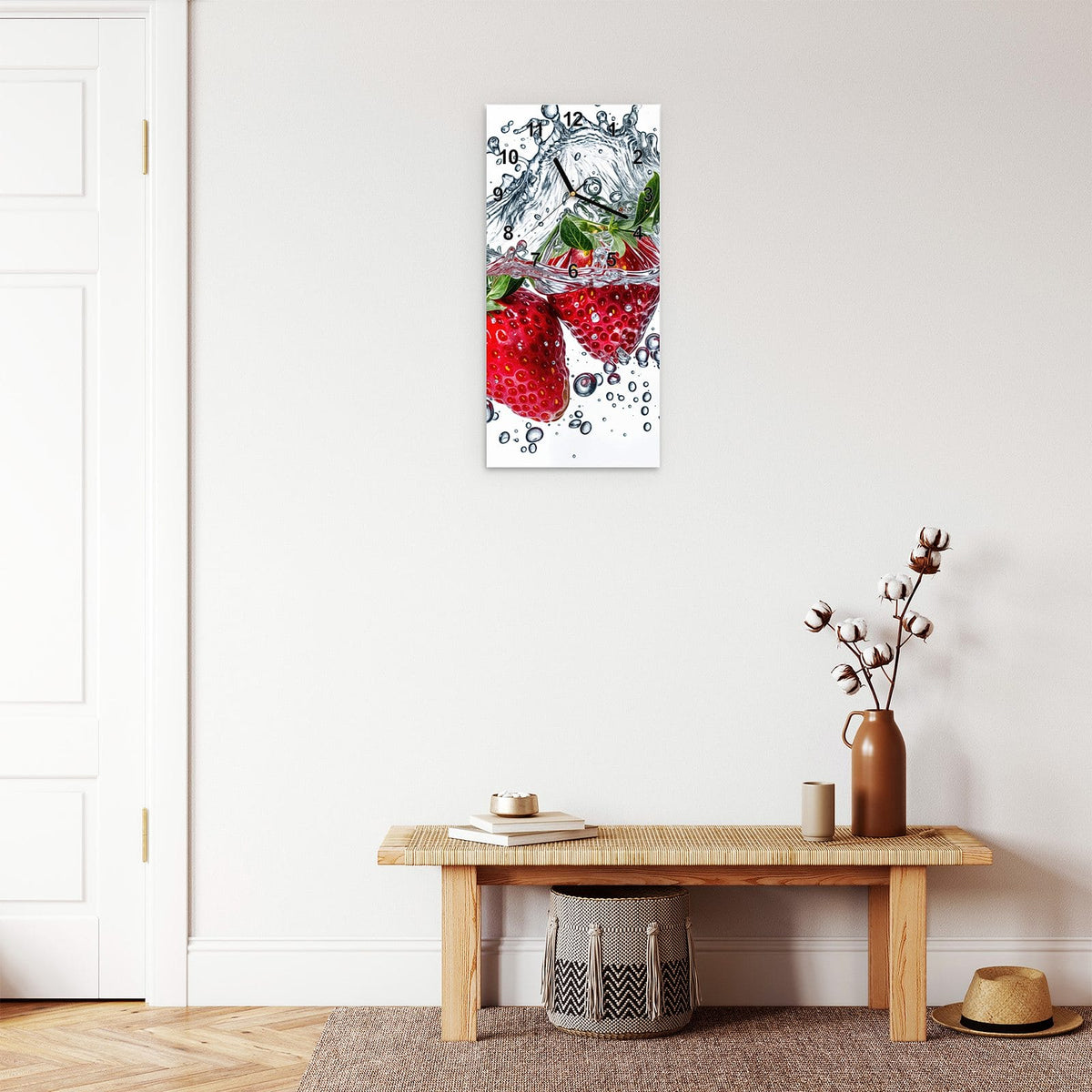 Wanduhr aus Glas im Hochformat Spritzige Erdbeeren mit Ziffernblatt Modern über einer Holzbank im Flur
